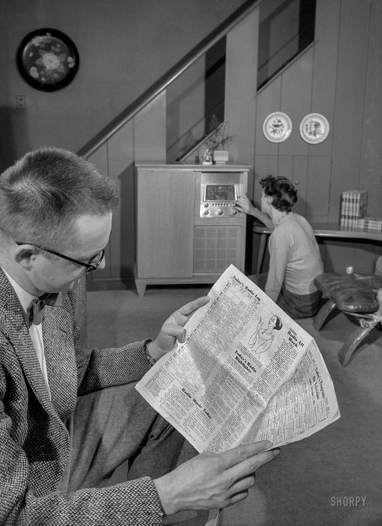 December 1957. Washington, D.C. "Man with broadcast listings; woman tunes radio." The console set, seen earlier here, is evidently a portable, or maybe this is a two-radio household. News Photo Archive 35mm negative. View full size.