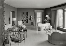 January 21, 1940. "Stephen A. Lynch Jr. residence, No. 3 Sunset Island, Miami Beach, Florida. Living room, general view. William Pahlmann, decorator; Robert Law Weed, architect." Gottscho-Schleisner photo. View full size.
Spotlessly cleanI'm guessing Mr. Lynch doesn't have a dog. Or a cat. Or kids. Or friends.
Wow, nothing to warm you up here.Having spent my formative years in the 1950s, I recognize some of the sparse and weird design influences going on here, but, it's still very strange by today's norms.  Glad we moved on from this strangely spartan and cold design model.
Five AshtraysAnd some joints ready to go. Gotta love Miami. 
Mid-century modern??That looks astonishingly like 1950s/1960s mid-century modern furniture. I've never seen such futuristic design in a photo as early as 1940. Mr. Lynch was definitely ahead of his time.
[The credit belongs to Mr. Pahlmann, avatar of mid-century design. -Dave]
S.A. LynchThe Sunset Islands are man made islands in Biscayne Bay created by Mr. Lynch.  The area is home to the rich and maybe famous.  Mr. Lynch was the son of a Civil War veteran.  He made his money in the early days of the film industry.  
https://en.wikipedia.org/wiki/Stephen_Andrew_Lynch.
YuckToo sterile looking for me. Let's live in it for a little.
I don&#039;t know much about artbut Mr. Lynch's collection looks like it was assembled in a hurry from the local thrift store. Still, tastes change. Eighty years from now, what will folks think of the homes of 2018?
Uninviting stillAs a young fellow in the late forties and early fifties, I can say these sorts of rooms were found fairly often- and were never comfortable to be in. I can't imagine this would have been any different even earlier. Glad it's over, like the others have said.
FlooredMy eye was immediately drawn to the floor tiles. I can well imagine this same shot taken forty years later with the edges all dried and curled.
[Those are ceramic tiles. - Dave]
Cold!Cozier than a doctor's waiting room, but not by much.
Well it&#039;s not onStar Island, but I guess it will just have to do.
Clapper beta?It would be great if the hands on the table on the right clapped to turn on the lamp.
Still searching for itBased on visits to other rooms just like this, I bet there's a crystal bowl containing 10 year old hard candies. 
50 Shades of GrayscaleYes, the room is a cold space —- in black and white. But the deep tone of the walls suggests a vibrant color that most certainly would have warmed the mood. 
Looming PresenceWhat is that item in the extreme left foreground that looks like the underside of a trampoline or of an industrial-strength cot?
UPDATE: Ah, it's a screen.  I found this image on EBay.
ColorsI would hope those walls are a deep rose color and the drapes a dusty rose, but if I remember the decade correctly, they are more likely to be a deep green with chartreuse drape. 
(The Gallery, Florida, Gottscho-Schleisner)