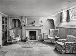 August 4, 1941. Nyack, New York. "Dr. E. Hall Kline, residence on North Broadway. George Munson Schofield, architect. Playroom, to fireplace." The other end of the pine-paneled basement last seen here. 5x7 inch acetate negative by Gottscho-Schleisner. View full size.
Well, now I&#039;m disappointedTwice, this room has been touted as a playroom.  But the bookcases make it look more like a library, except, there are no lamps next to the chairs to read by.  Where's a table and chairs suitable for playing chess, checkers, backgammon, poker, bridge, Monopoly, or Scrabble? Where's the pool table?  I like the slate floor, but the only thing this room is set up for is conversation, charades, or taking turns flipping playing cards into a hat while you drink too much.
Even the pheasant can't make this a game room (joke). 
(The Gallery, Gottscho-Schleisner)