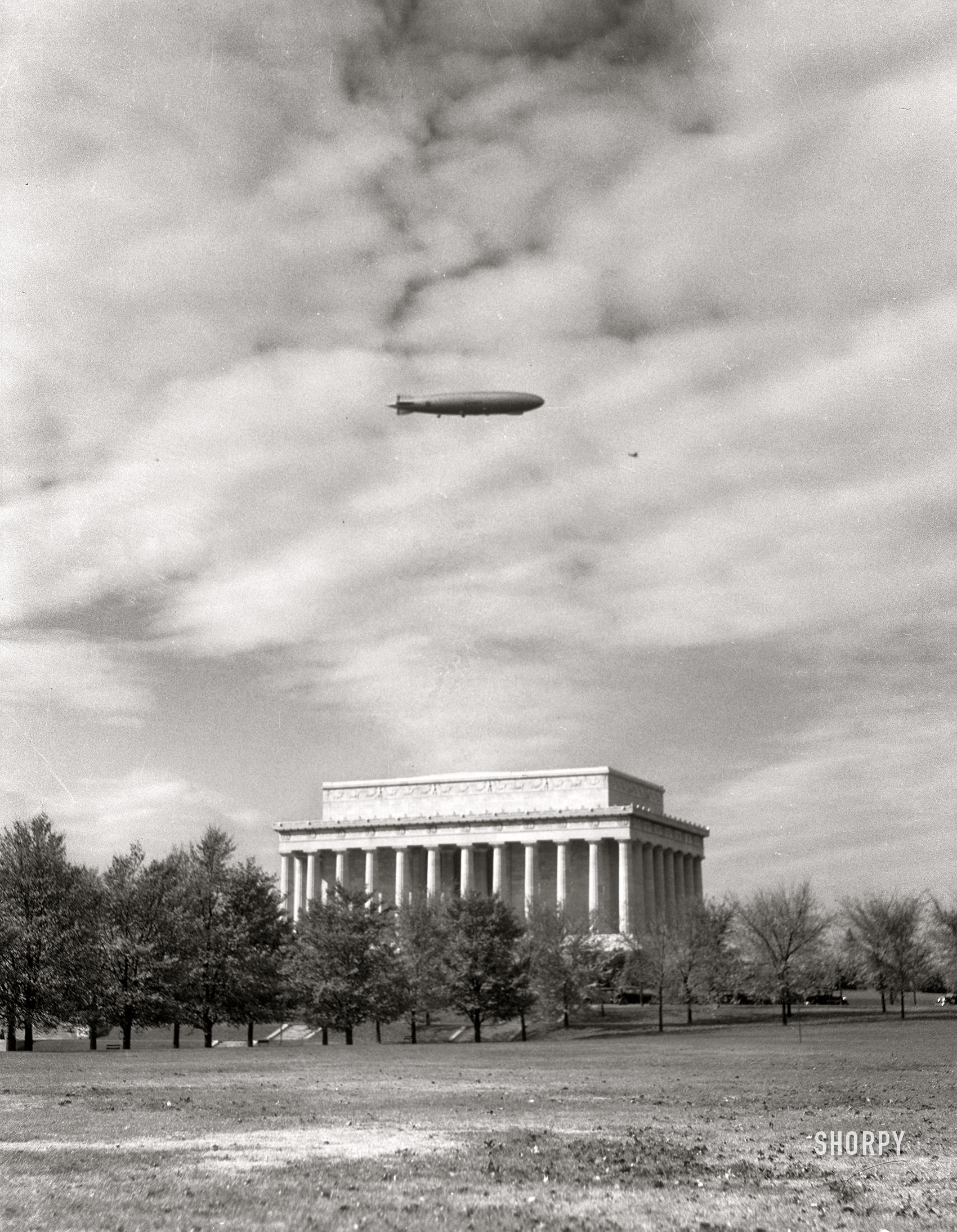 &nbsp; &nbsp; &nbsp; &nbsp; UPDATE: The aviation experts among us aver that the photo shows the USS Los Angeles, not the Akron. In which case the date would be November 2, 1931, when both airships overflew the capital.
August 19, 1932. The Lincoln Memorial in Washington, D.C. "The Navy airship Akron appeared in the morning and after circling the city released several of her small fighting airplanes over Hoover Field. These were later drawn into the hangar constructed on the interior of the airship." 4x5 inch nitrate negative by Theodor Horydczak. View full size.