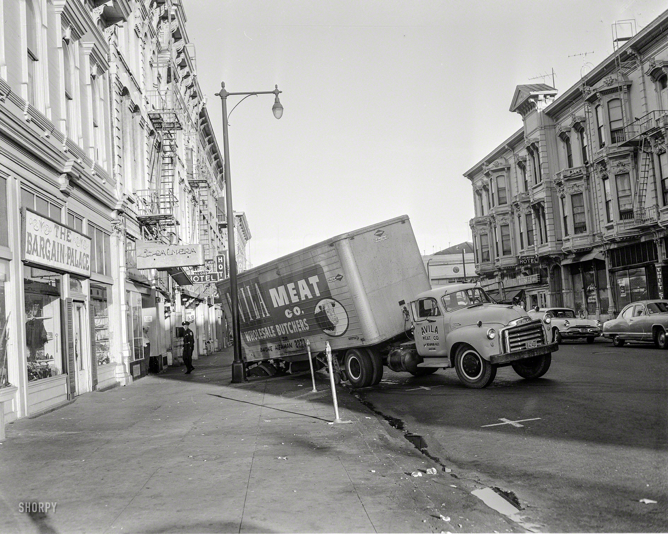 Oakland, California, circa 1957, and another motoring mishap -- an Avila Meat Co. truck that seems to have broken through the sidewalk. View full size.