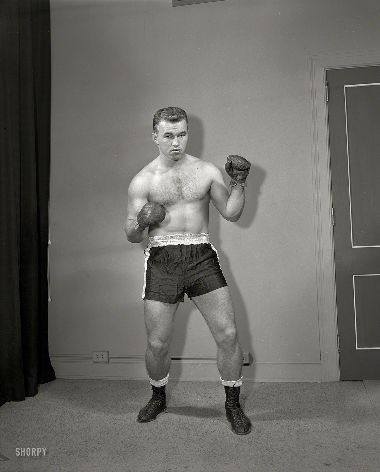 From sometime in the 1950s in the vicinity of Columbus, Georgia, comes this unidentified pugilist. 4x5 acetate negative from the News Archive. View full size.