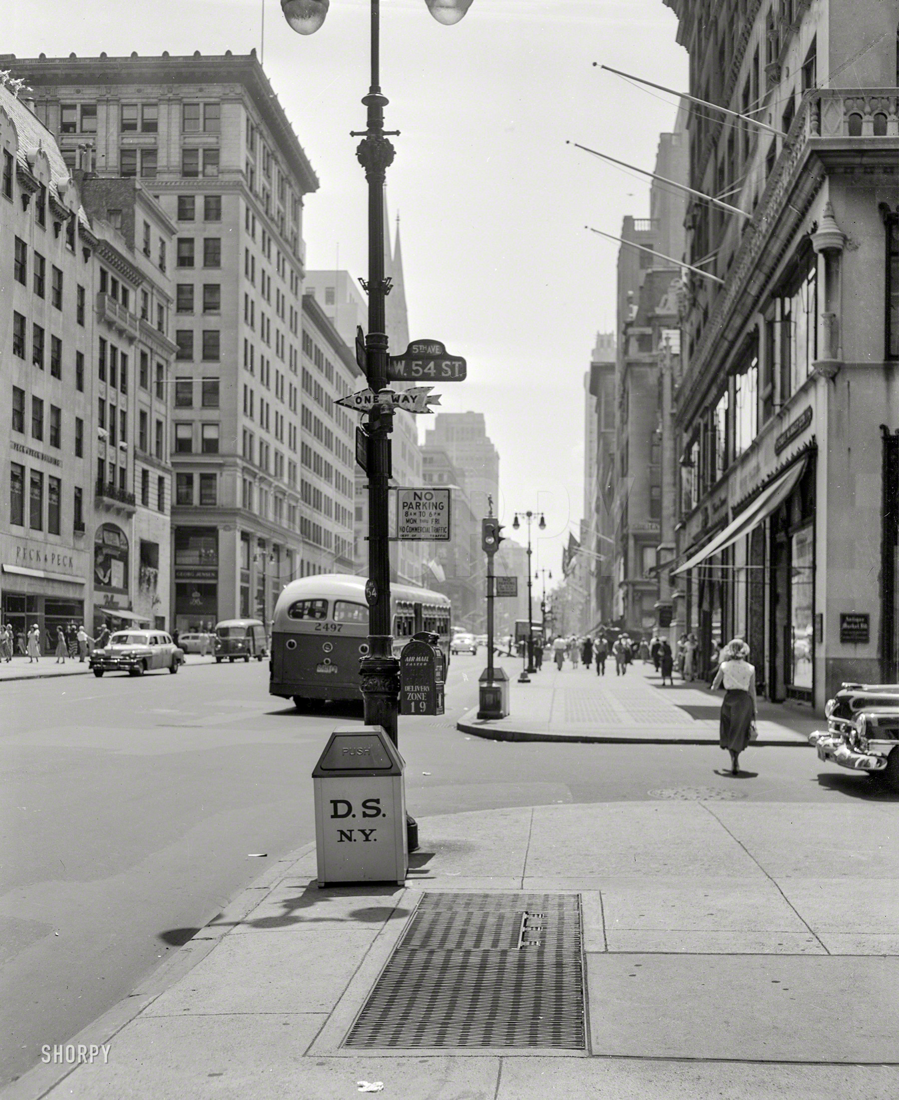 July 1953. "Fifth Avenue at W. 54th Street." And, according to the lamppost mailbox, Delivery Zone 19. 4x5 negative from the News Archive. View full size.