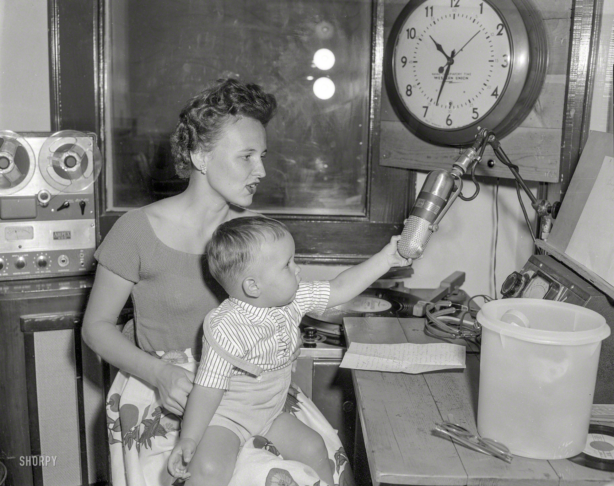 For Columbus Day we return to 1950s Columbus, Georgia, for this uncaptioned News Archive snap of a lady and a baby with a bent for broadcasting. It's 10:33. Do you know where your children are? 4x5 acetate negative. View full size.
