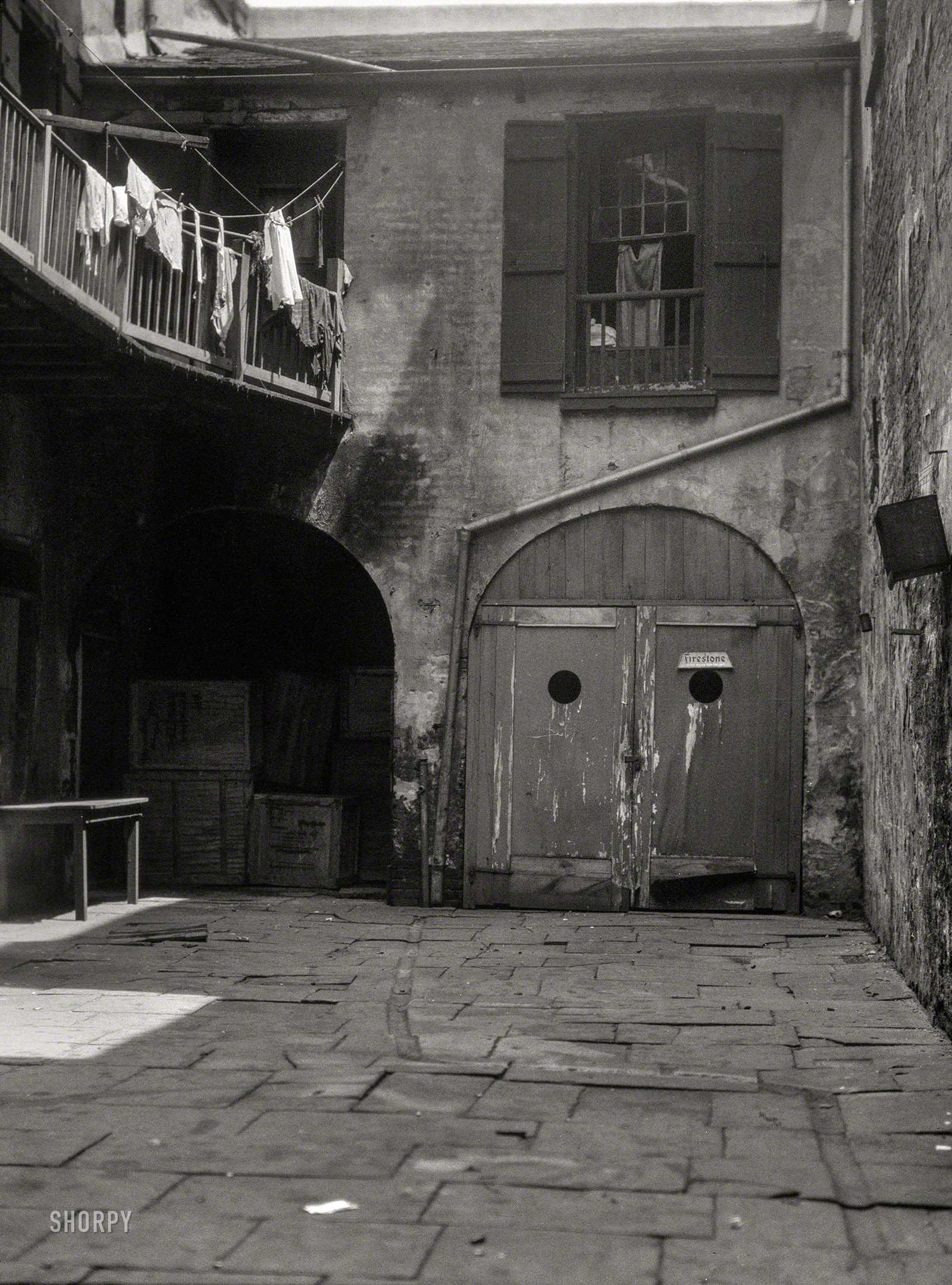 New Orleans circa 1925. "View of a courtyard." Evidently the rear entrance to Club Firestone. Note the zigzag extension of the downspout under the patio flags. Nitrate negative by Arnold Genthe. View full size.