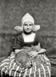 March 3, 1913. "Miss Marjorie Silvester and Buzzer the cat." Favored furry prop in the portrait studio of Arnold Genthe. 5x7 glass negative. View full size.