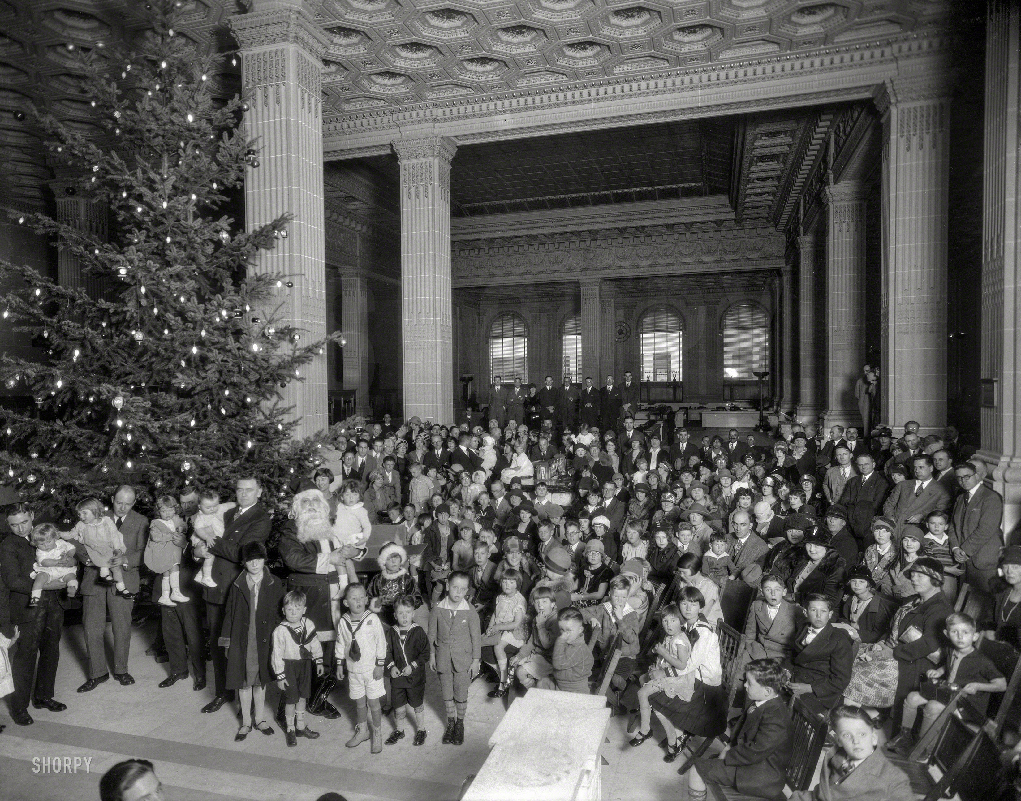 &nbsp; &nbsp; &nbsp; &nbsp; Before getting to all those department stores, Santa has to hit the bank. Leave your checkbook at home, but bring the kids!
December 1925. "Christmas tree and Santa Claus at Crocker National Bank, Post & Montgomery Streets, San Francisco." 8x10 nitrate negative, formerly of the Wyland Stanley and Marilyn Blaisdell collections. View full size.