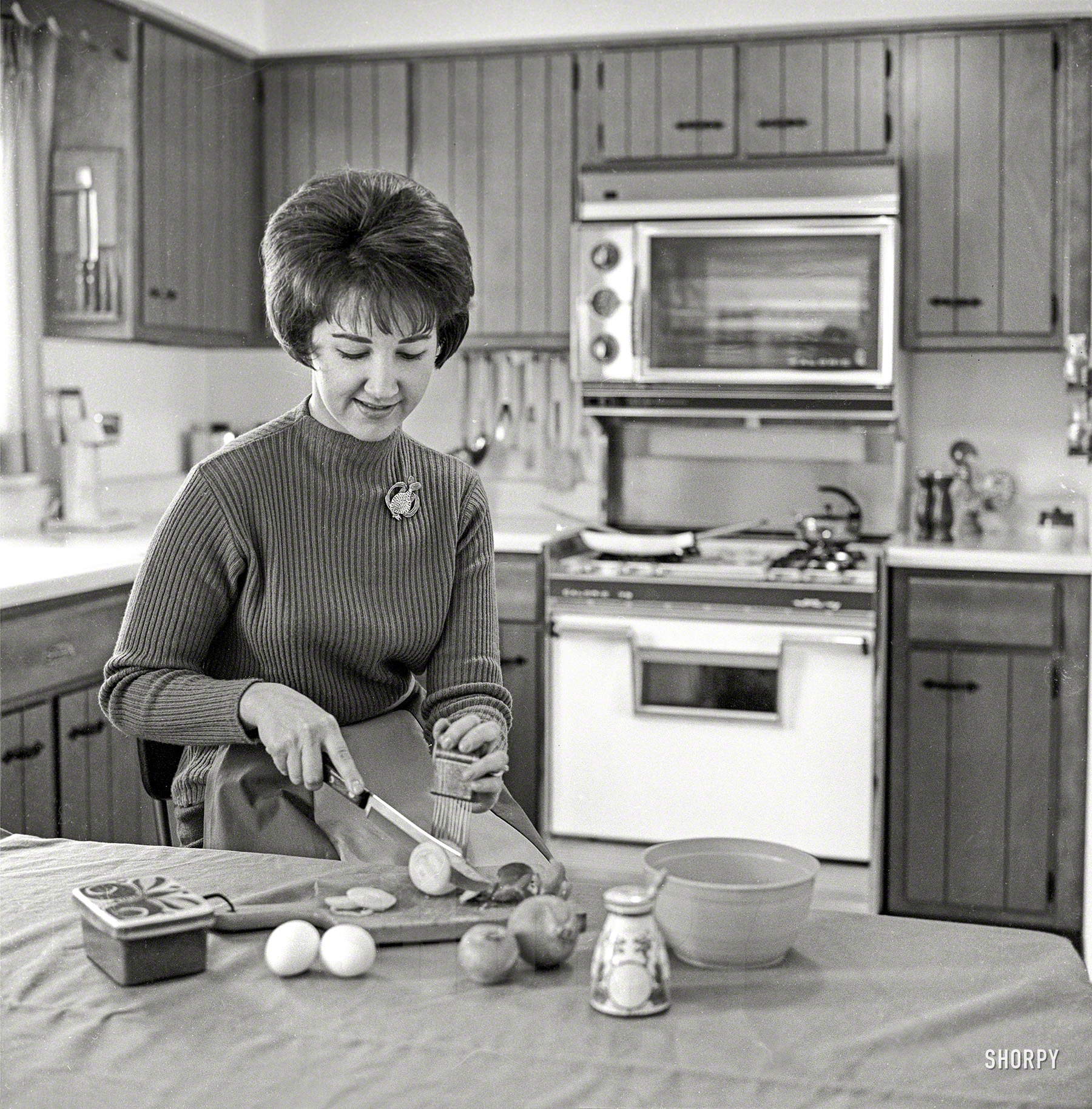 From Chicago circa 1965 comes this uncaptioned snap of a lady in a kitchen showing an onion who's boss. Other ingredients include two eggs and a fish. Medium format negative from the News Photo Archive. View full size.