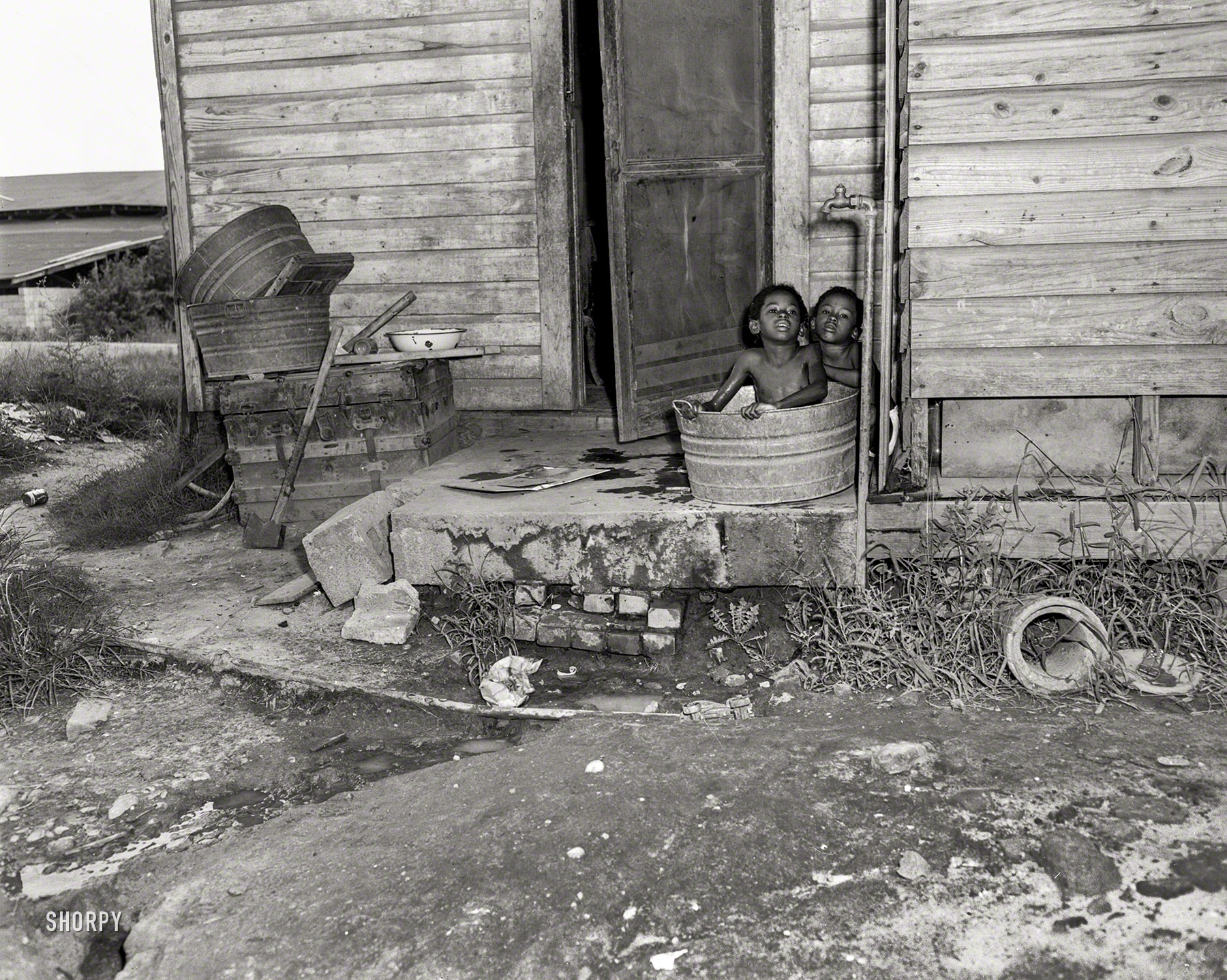 Columbus, Georgia, circa 1950, and another still from the "housing" series, showing the opposite of an en suite bath. 4x5 acetate negative. View full size.