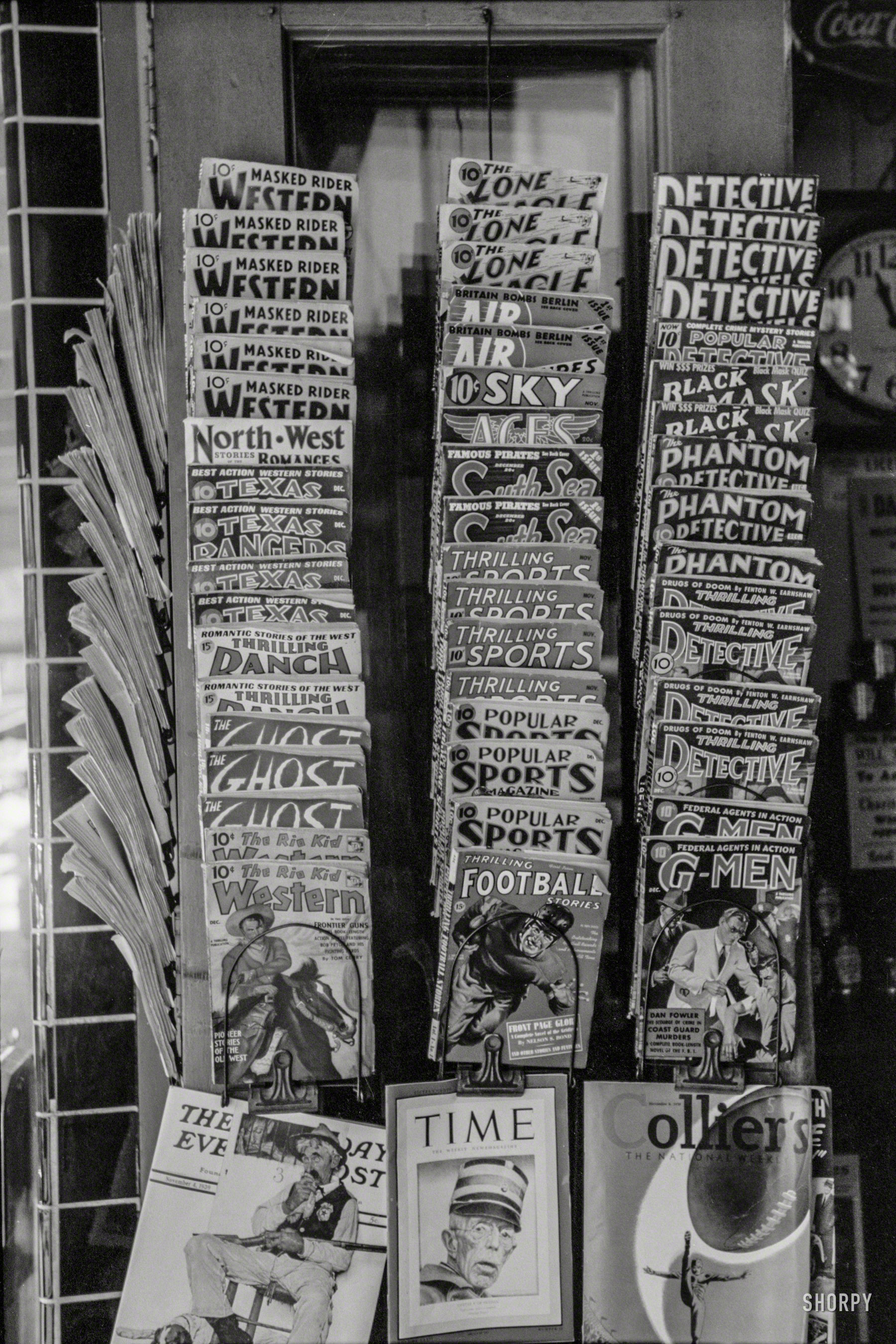 October 1939. "Display of magazines for sale in Taylor, Texas." We'll take one of each, please. 35mm nitrate negative by Russell Lee. View full size.