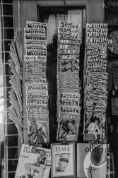 October 1939. "Display of magazines for sale in Taylor, Texas." We'll take one of each, please. 35mm nitrate negative by Russell Lee. View full size.
PulpsI collect pulp magazines and to see a photo like this is like being a kid in a candy store. They might have sold for a dime at the time, but even a pulp in the sorriest condition will sell for $20 today. If you want a sought-after issue in respectable condition, it may run a couple hundred dollars.
I hope this newsstand also carries bags and boards.
The boring ones on the bottomThe Saturday Evening Post and Collier's are dated November 4, 1939.  The Time magazine (with a picture on the cover of King Gustav V of Sweden, of all people) is dated October 30, 1939. 
Pricing according to demand?Hmm. So, Thrilling Football (and nearly all the others) are 10 cents. But Thrilling Ranch is 15 cents (for the prurient inside, we must pay a bit more). And, our lowly Saturday Evening Post, a paltry 5 cents.
Thrilling Ranch, Thrilling Sports,And our latest publication, Thrilling Display Racks!
1st EditionThe Thrilling Football Stories shown is the first (and maybe only) edition of that pulp. Two copies on eBay right now, one asking $99, the other twice that.
(The Gallery, Russell Lee, Stores & Markets)