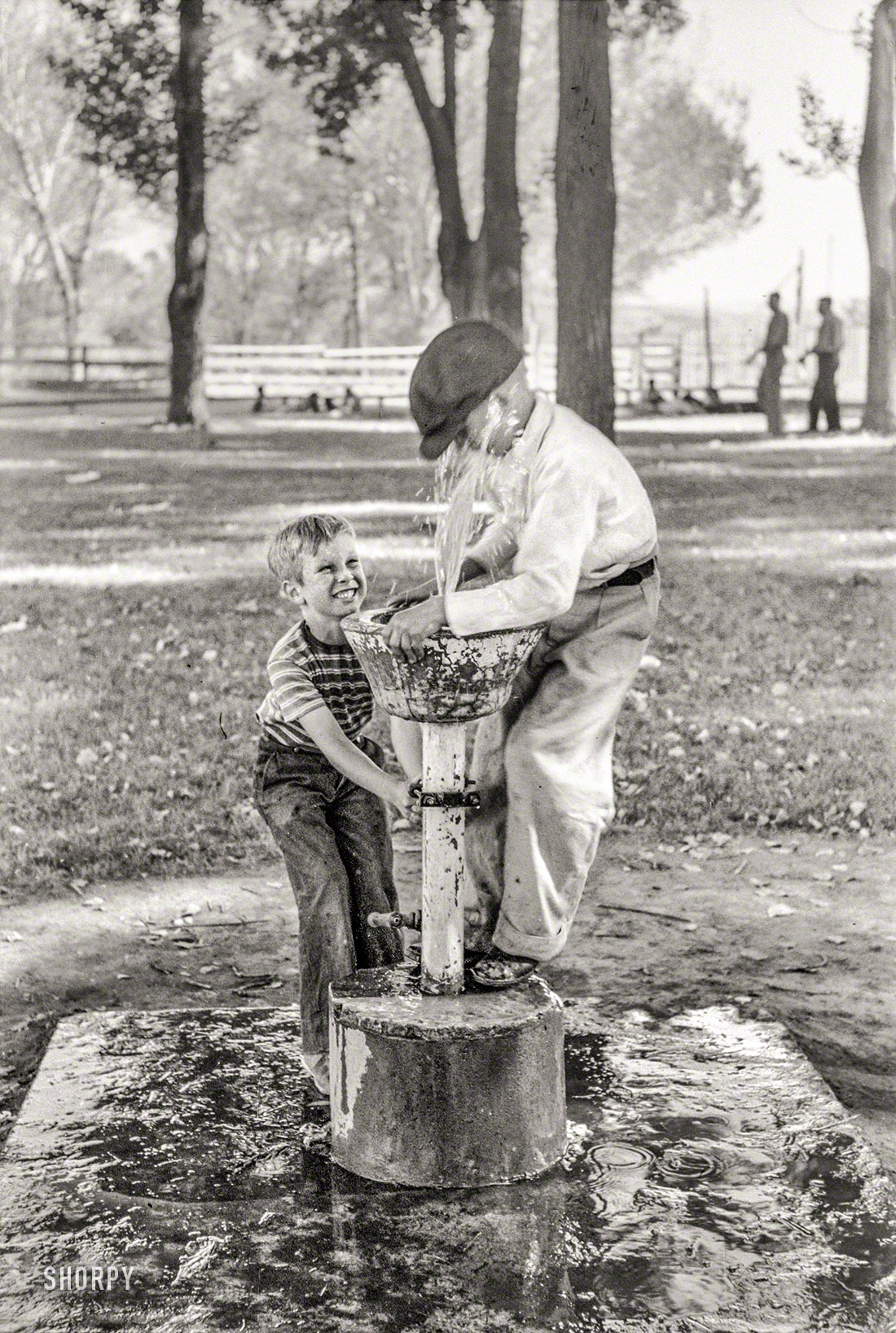 July 1941. "Fun at the water fountain. Fourth of July picnic in Vale, Oregon." Photo by Russell Lee for the Farm Security Administration. View full size.