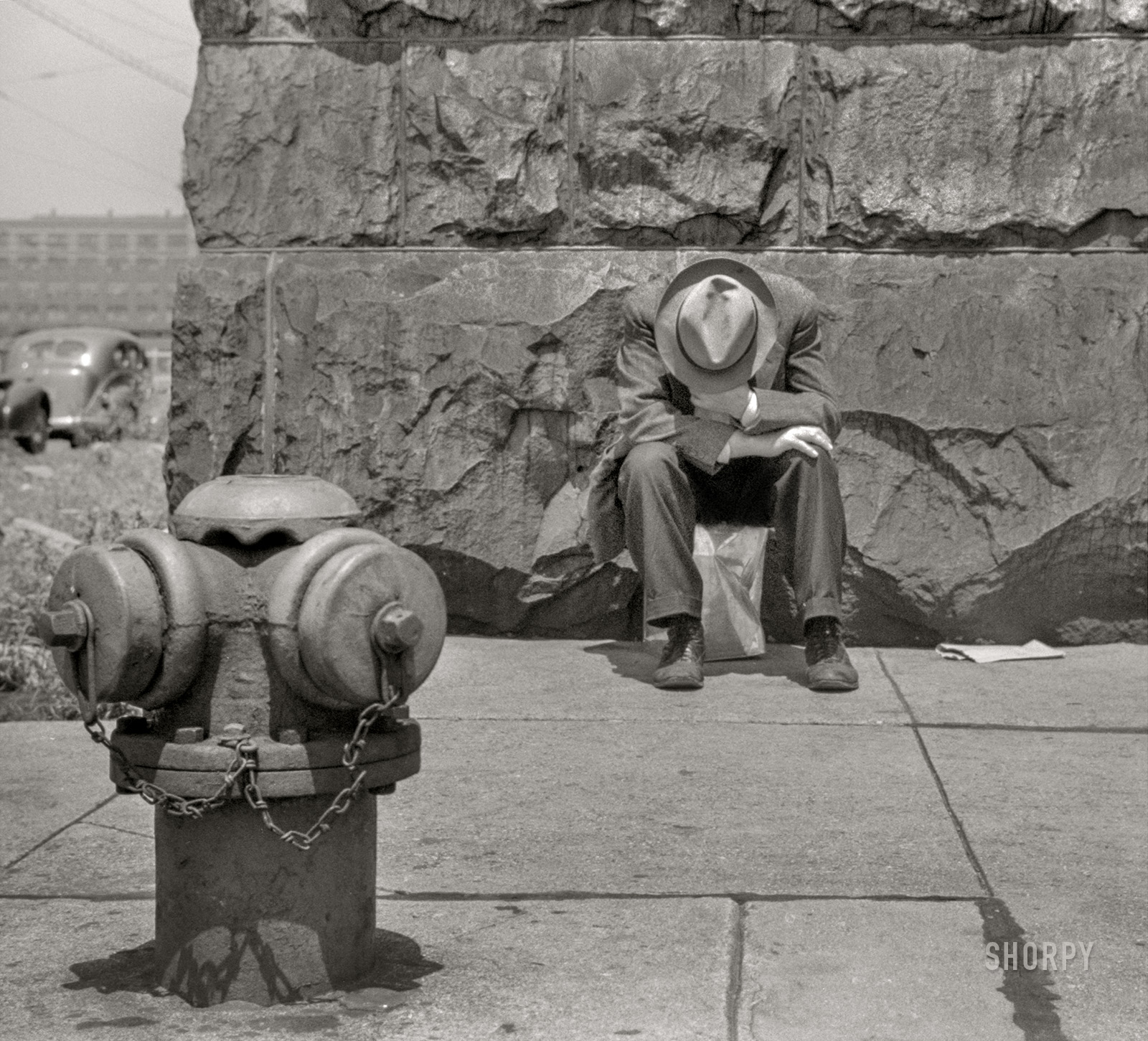 July 1941. Chicago. "Man seated on corner of Jefferson Street and Vernon Park Place." 35mm acetate negative by John Vachon for the Farm Security Administration. View full size.