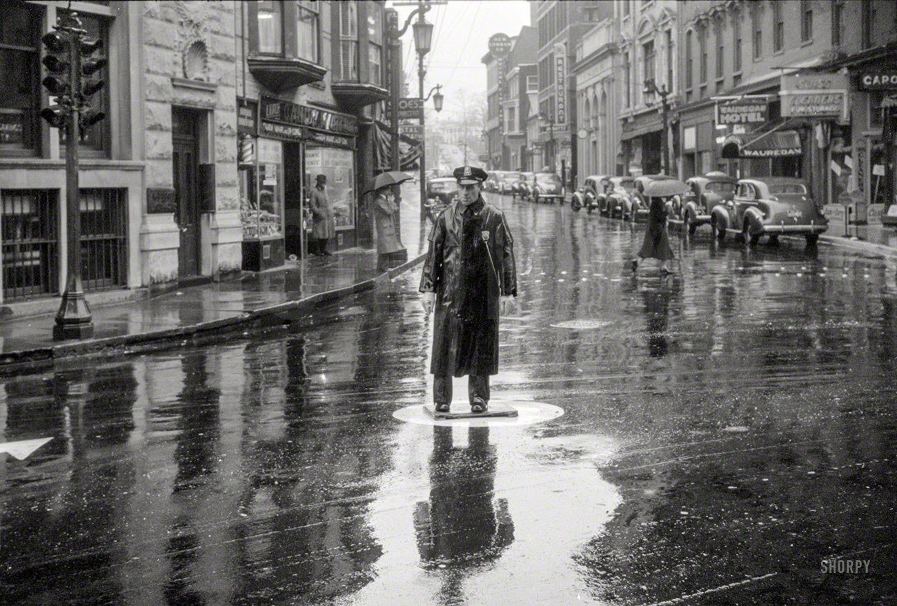 November 1940. "Street scene on a rainy day in Norwich, Connecticut." Traffic Cop vs. Traffic Light. 35mm nitrate negative by Jack Delano. View full size.