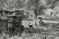 From September 1938, a reminder of the days when doing laundry meant hauling water from a well or spigot, then boiling it in a caldron over a fire: "Old and sick, mine foreman's wife does washing in front yard. South Charleston, W.Va." Photo by Marion Post Wolcott for the Resettlement Administration. View full size.
Body PartsI sure would like to have that Ford door!  Thats the reason we often find the cars and trucks with no doors. They took them off!
Jack In The BoxSeems the foreman's son loved playing in boxes as much as I did as a child.  This yard is a playground full of treasures for a boy and his imagination.
Mine foreman&#039;s wifeShe is described in the caption as old and sick.  Having to do such a strenuous, miserable chore weekly would make anyone old and sick before their time. A coal miner's clothes and almost everything he touches, often including his hair and skin, become indelibly stained with coal residue, very difficult to clean.  She probably also made her own lye soap in a similar cauldron over a fire.  I almost missed seeing the two kids playing in a makeshift clubhouse under the tree in the background.  At least that lends a small ray of cheerfulness into this family's difficult life of mostly drudgery.  
Foreman&#039;s wifeImagine what life was like for an ordinary miner's wife.
Not quite right"think it needs a pinch of Salt"
What a kid really wantsA packing crate. Even today a cardboard refrigerator box will become a magic carpet for a kid.
Could be my grandma&#039;s place!Grandpa was a farmer, not a miner, but their backyard looked very much like this, including the "Witches Cauldron" where clothes were boiled on washday. Then the wringer washer showed up when i was maybe 8 or 10 and things changed...
They had a 1950 ickup truck in green, and a 1957 Chevy sedan in silver, no radio and without self-canceling turn signals. No frills neded for gramma and grampa!
Happy BirthplaceI was born in South Charleston three years after this picture was taken. It is hard to believe there was an actual hospital there.
Through the WringerEven I remember, although the water came from a tap, that in the early fifties, living in a comfortable home with central heating, the maid did the wash in a washtub, using washboard and hand wringer. As a small boy I protested to my parents that they could not let this happen. And soon a washing machine came in the house.
(The Gallery, M.P. Wolcott)