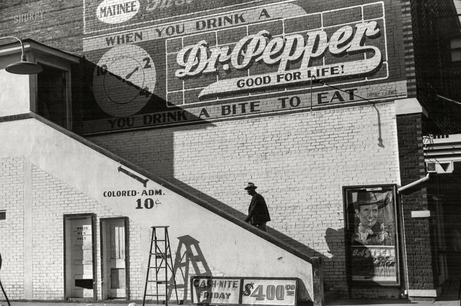 October 1939. "Belzoni, Mississippi, in the Delta area. Negro man entering movie theater by 'Colored' entrance." 35mm nitrate negative by Marion Post Wolcott for the Farm Security Administration. View full size.