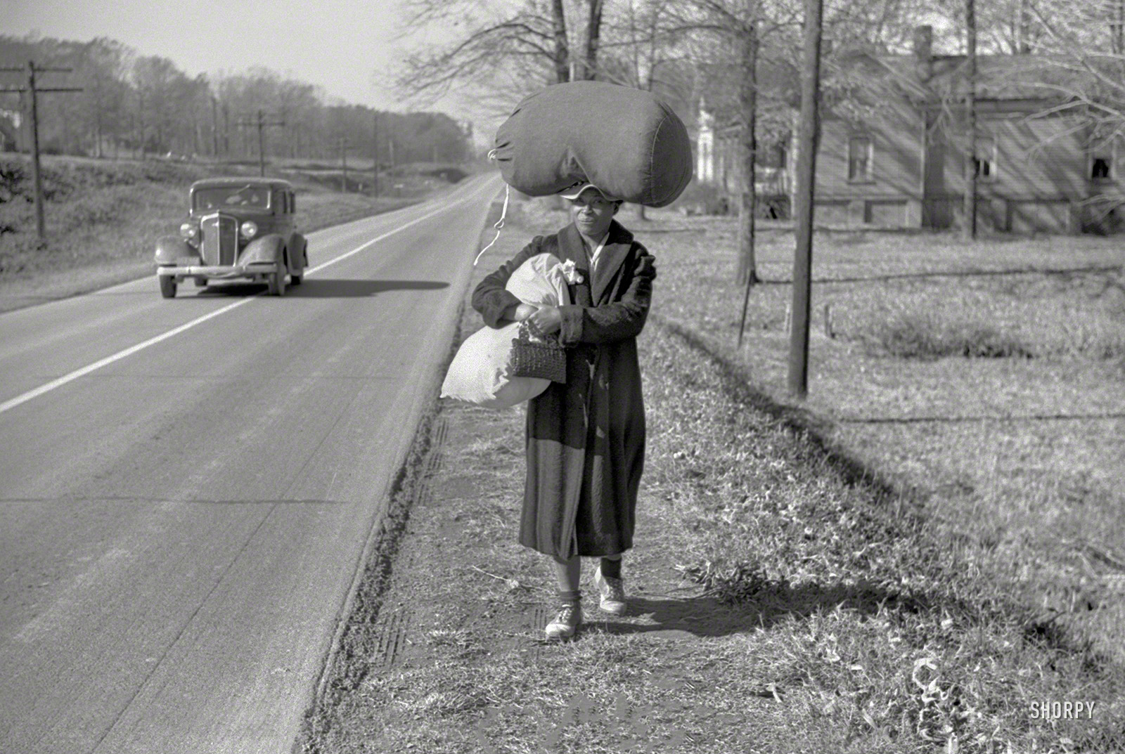 &nbsp; &nbsp; &nbsp; &nbsp; For millions of women across America in the first half of the 20th century, working from home might mean "taking in wash" for another family.
November 1939. "Negro woman carrying laundry home along highway between Durham and Mebane, North Carolina." 35mm nitrate negative by Marion Post Wolcott for the Resettlement Administration. View full size.