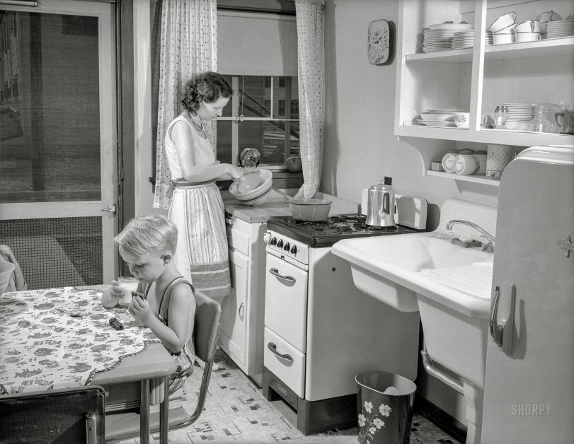 July 1941. "War housing. Mrs. B.J. Rogan and her small son, Bernie, in the kitchen of the Rogans' new war home at the Franklin Terrace housing project in Erie, Pennsylvania. Mr. Rogan is a drill press operator at a nearby plant which is working three shifts on war contracts. The Rogans pay about twenty percent of their income for rent." Medium format acetate negative by Alfred Palmer for the U.S. Office for Emergency Management. View full size.
