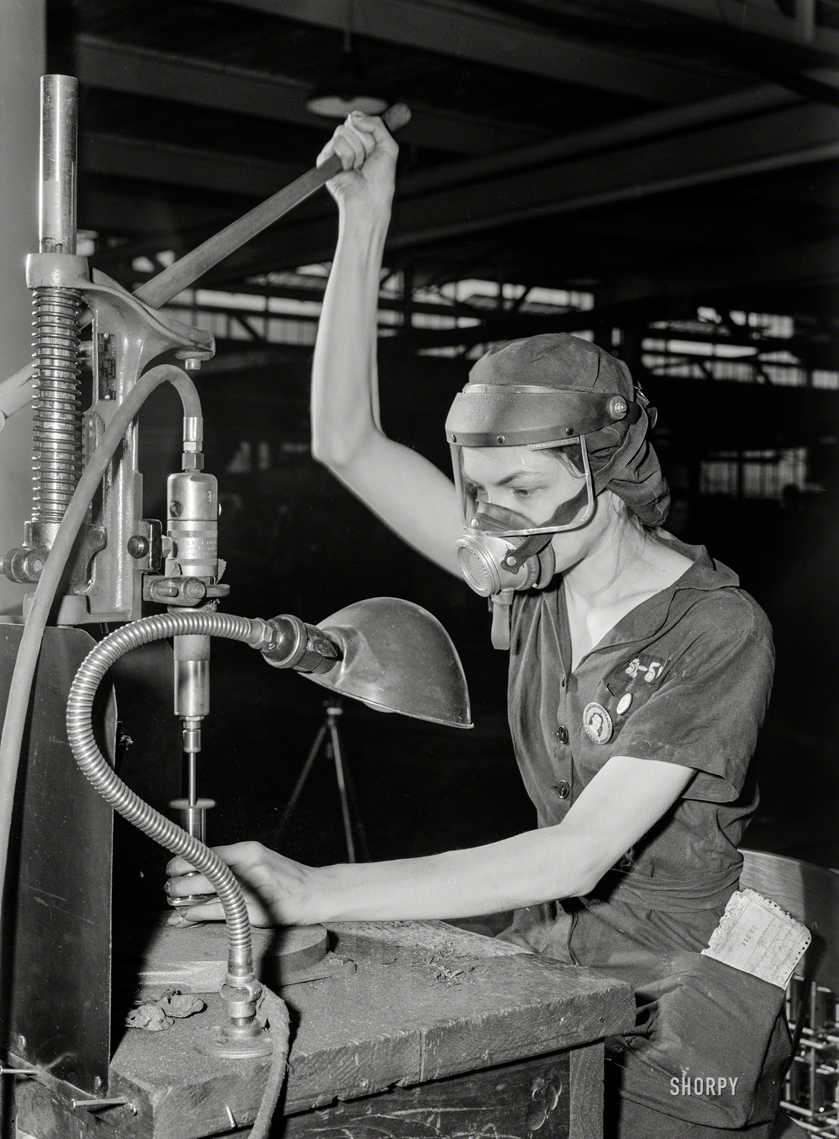 August 1942. "Women in industry. Aircraft motor workers. A million-dollar baby, not in terms of money but in her value to Uncle Sam, 21-year-old Eunice Hancock, erstwhile five-and-ten-cent store employee, operates a compressed-air grinder in a Midwest aircraft motor plant. With no previous experience, Eunice quickly mastered the techniques of her war job and today is turning out motor parts with speed and skill. Note protective mask and visor, two vital safety accessories." Photo by Ann Rosener for the Office of War Information. View full size.