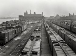 September 1942. The Kroger warehouse in Pittsburgh, Pennsylvania. "Freight car movements. With transportation assuming vast new importance in wartime America, movement of freight cars must be accomplished with the fullest efficiency and speed. Loss and diversion of ocean carriers which served our seaboard cities have thrown an enormous burden upon the railroads." 4x5 inch nitrate negative by Ann Rosener for the Office of War Information. View full size.
Another view of the Kroger warehouseHere.
Not just freight cars.But refrigerated box cars.  A great detail shot of a "Reefer's" ice hatches.
Put A Cork In It, SonNearly all of the tracks in the foreground are long gone except for a couple of the old Allegheny Valley RR that ran right down the middle of Railroad  Street. The Kroger warehouses are also gone but larger and looming in the distance of the old photo is the still extant twin buildings of the huge Armstrong Cork Co. now turned into loft style living for those wanting an historic pad with a river view in the Steel City.
Strip District dazeThis looks like the strip as viewed from the 16th Street Bridge.  I believe the church on the far right is St. Stanislaus that faces down Smallman Street.
Quite a jointAre those reefers the walker is inspecting?
(The Gallery, Ann Rosener, Pittsburgh, Railroads, WW2)