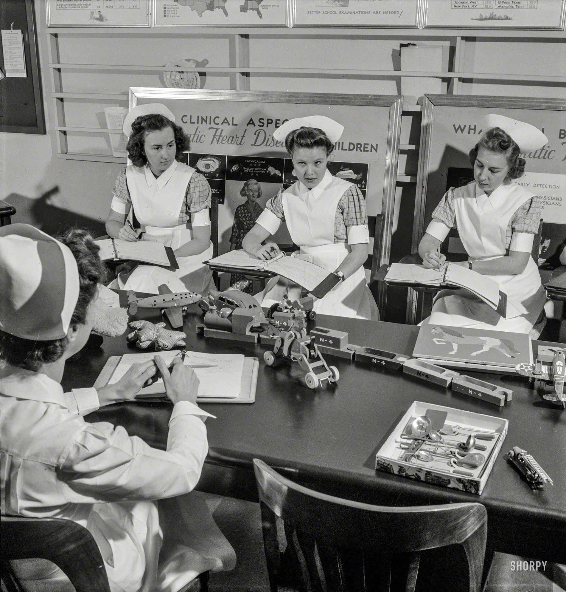 November 1942. Babies' Hospital, New York. "Nurse training. Through classes in pediatrics, student nurses learn how the right toys can be almost as important as medicine and diet in getting a sick child well. Encouraging an interest in play and normal activities of childhood hastens convalescence." Medium format nitrate negative by Fritz Henle for the Office of War Information. View full size.