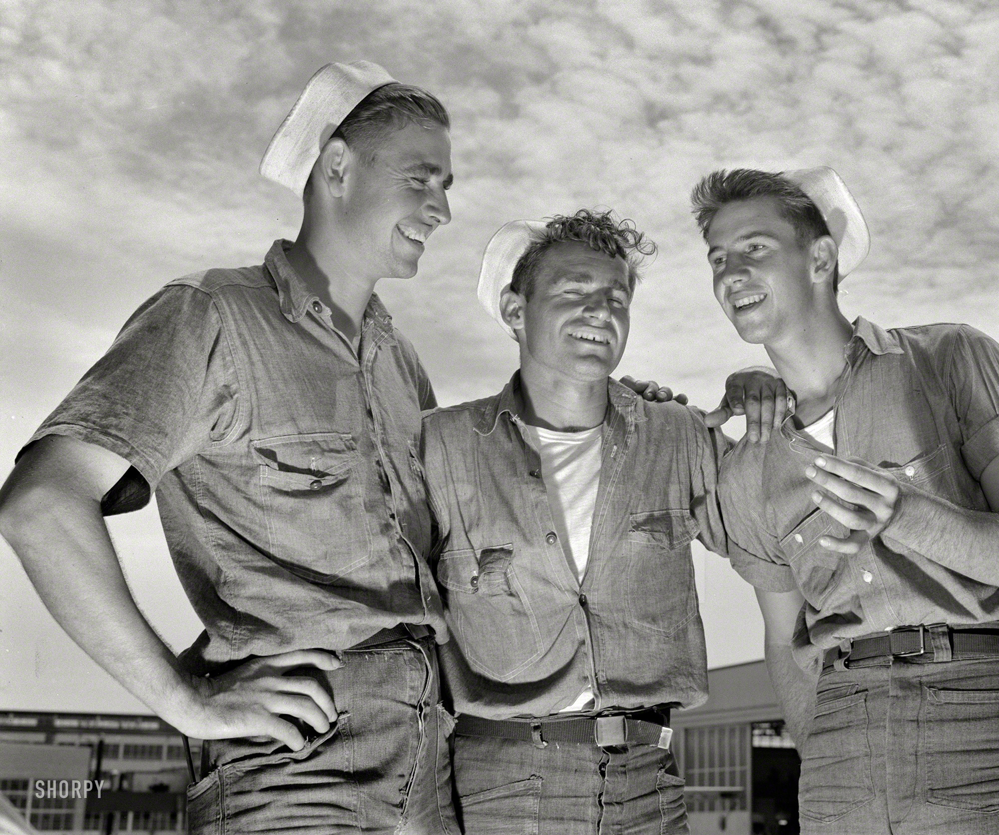 August 1942. "And so he says to me --  Sailor mechanics at the naval air base in Corpus Christi, Texas, laugh heartily over a good story between servicing operations on Navy planes." 4x5 inch nitrate negative by Howard Hollem for the Office of War Information. View full size.