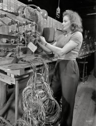 December 1942. "Checking electrical wiring assemblies for B-17F (Flying Fortress) bombers at the Boeing plant in Seattle." Photo by Andreas Feininger for the Office of War Information. View full size.