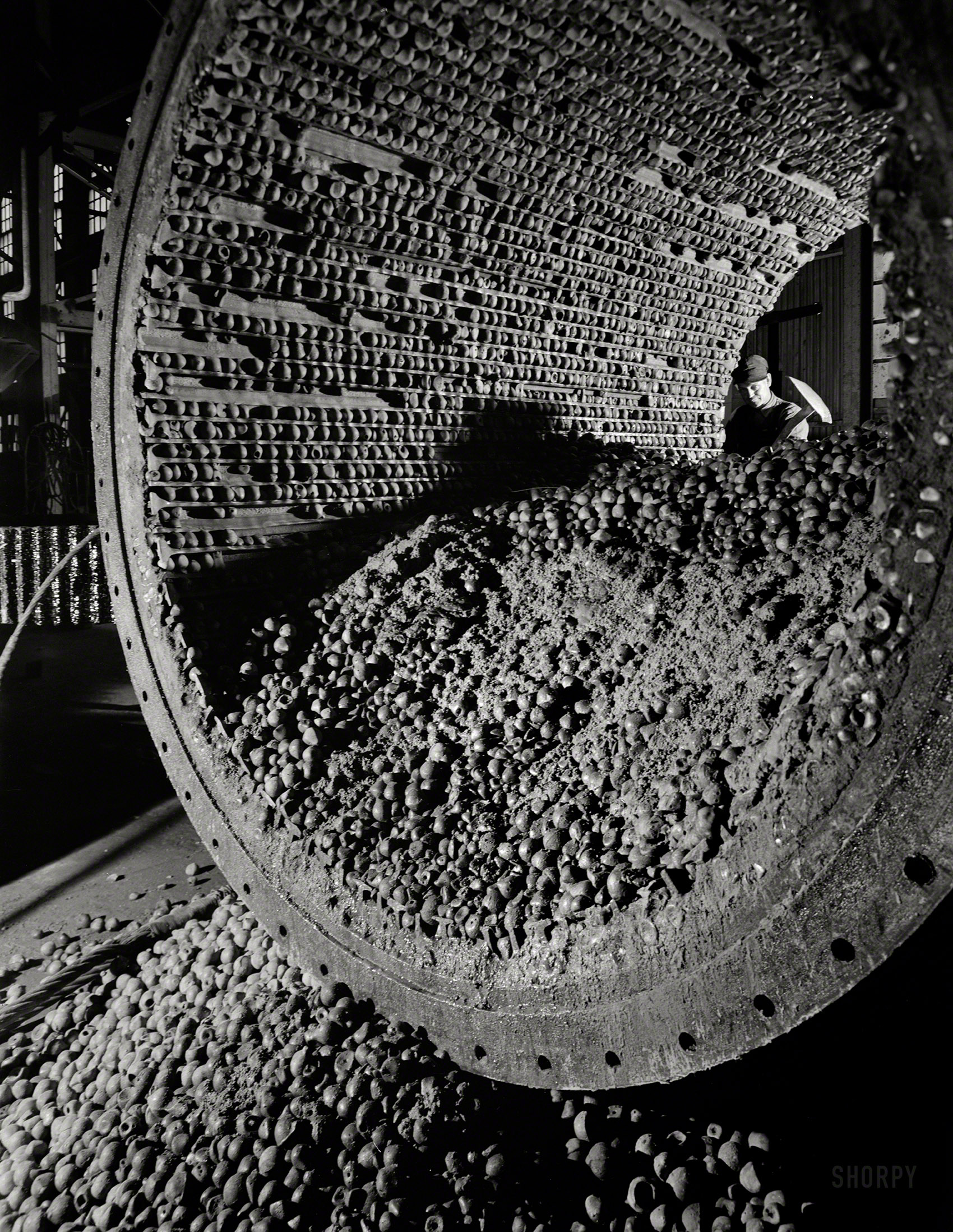 November 1942. "Production. Copper. Interior of large ball mill showing the iron balls which grind the ore to a fine size for subsequent treatment by flotation at one of the mills of the Utah Copper Company in Magna and Arthur." 4x5 nitrate negative by Andreas Feininger for the Office of War Information. View full size.