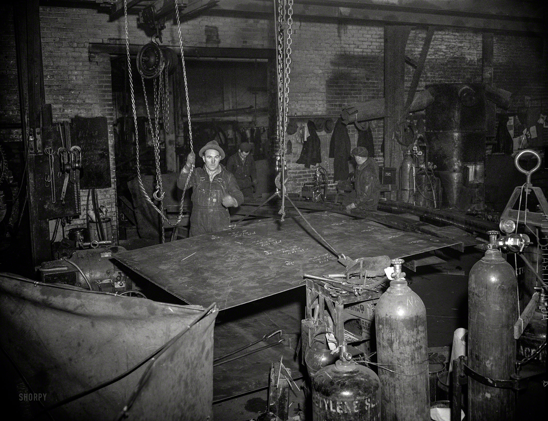May 1942. "Denver, Colorado. Interior of a shipbuilding plant, showing workman who previously assembled incubator parts and amusement park devices, now working on hulls and decks of escort vessels. He and his co-workers will be invited to Mare Island, 1,300 miles away, to help launch the ships they are building." 4x5 nitrate negative for the Office of War Information. View full size.