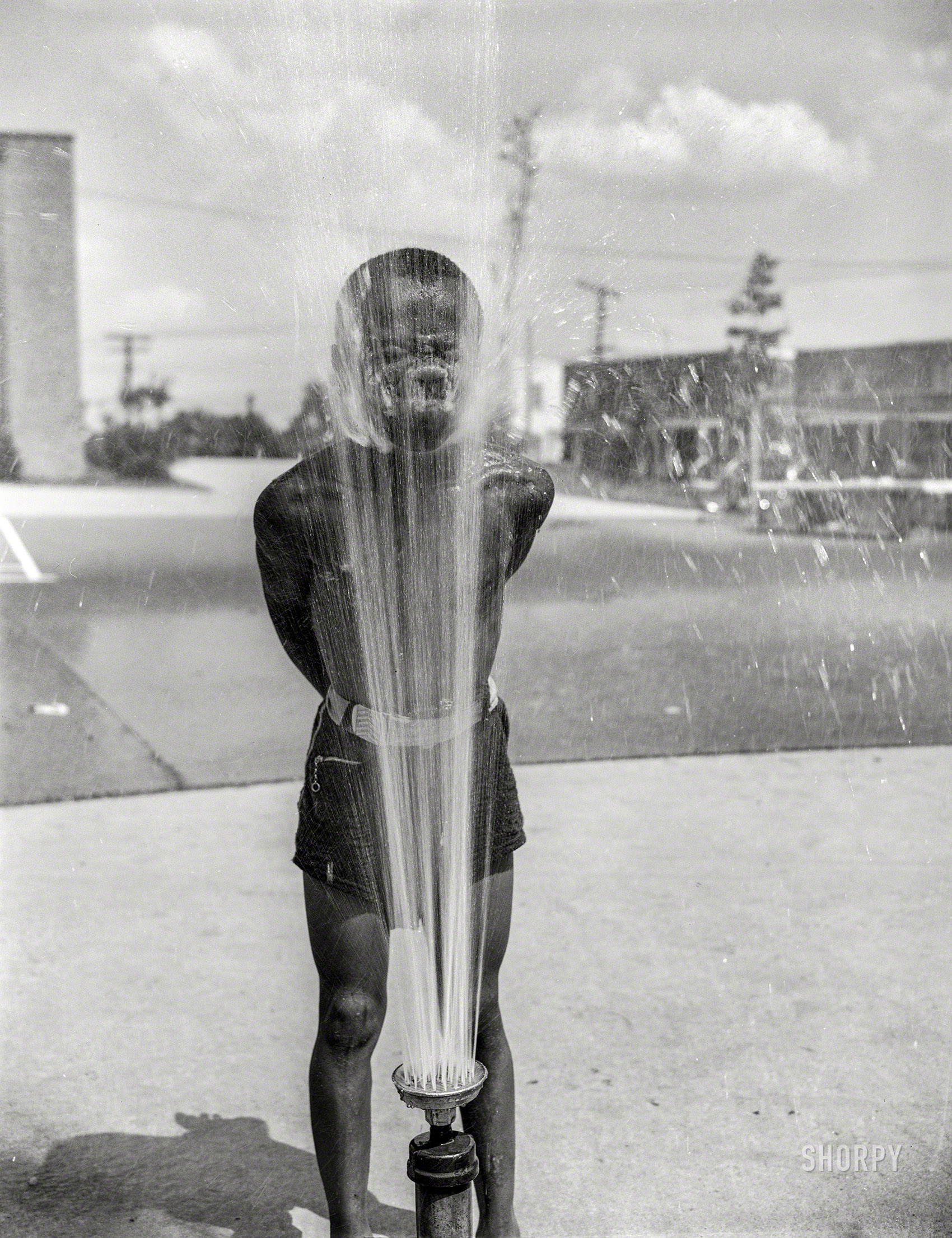 June 1942. Washington, D.C. "Frederick Douglass housing project in Anacostia. Playing in the community sprayer." Photo by Gordon Parks for the Office of War Information. View full size.
