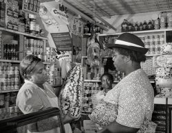August 1942. Washington, D.C. "Housewife bargaining in the store owned by Mr. J. Benjamin." Photo by Gordon Parks, Office of War Information. View full size.