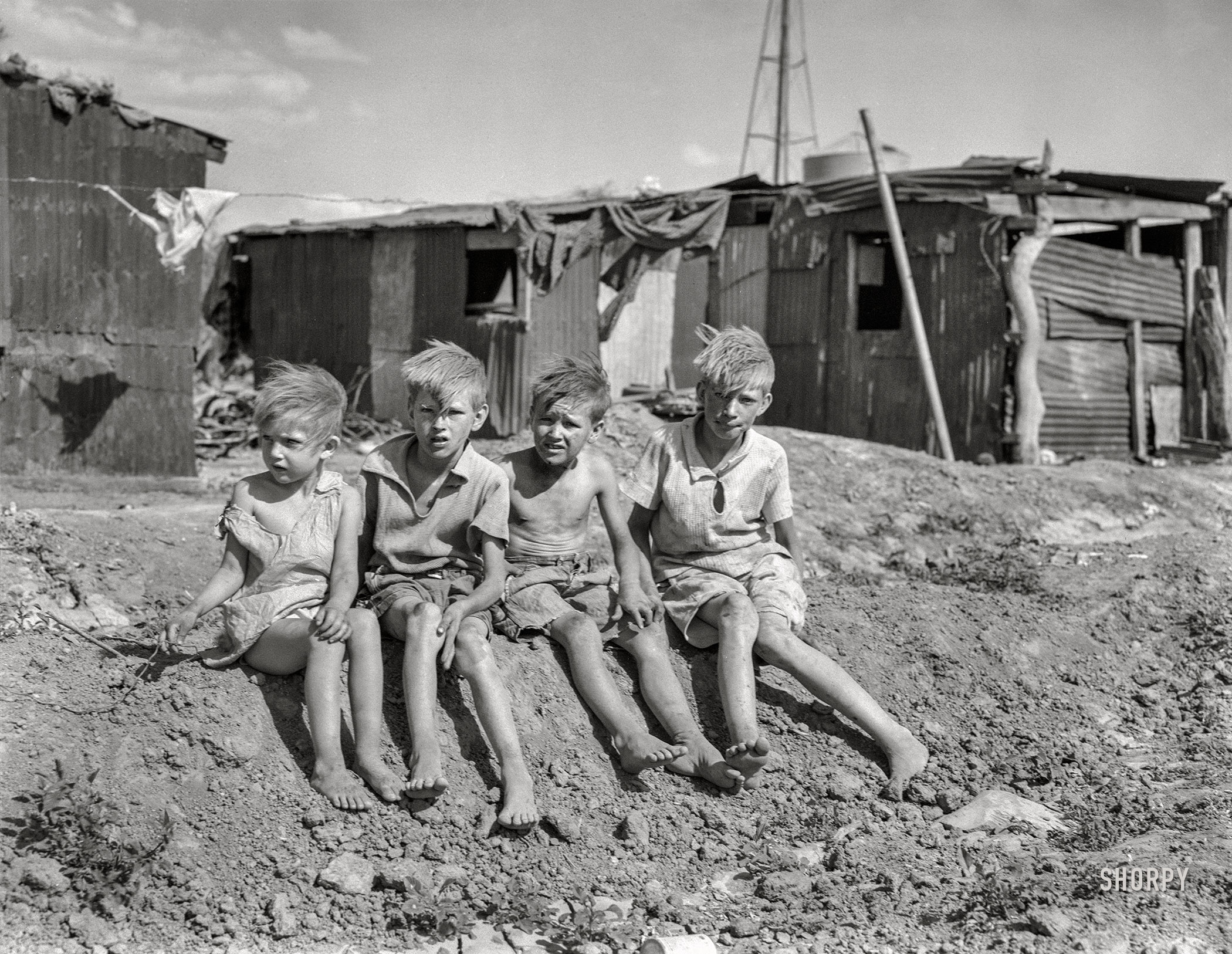 May 1937. "Children of migrant cotton field workers from Sweetwater, Oklahoma. Eight children in the family. Note the housing. Near Casa Grande project, Arizona." Medium format acetate negative by Dorothea Lange for the Farm Security Administration. View full size.