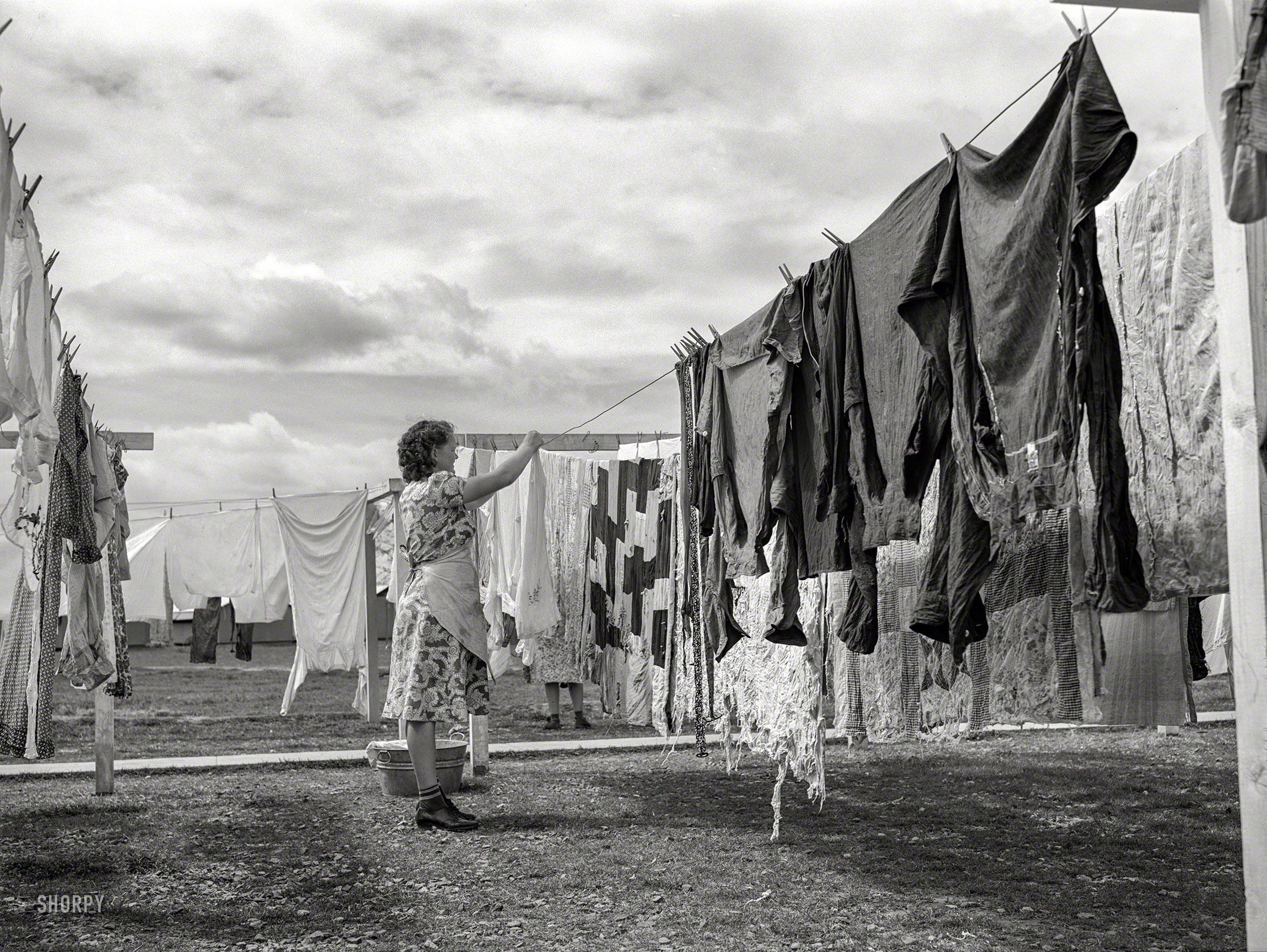 March 1940. "Woman hanging clothes to dry. Laundry equipment is in constant use. Tulare migrant camp. Visalia, California." Medium format acetate negative by Arthur Rothstein for the Farm Security Administration. View full size.