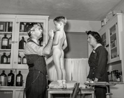 December 1941. "Dr. Tabor examining Randolph Darkey, before inoculating him against measles, in the community health center. Dailey, West Virginia." Photo by Arthur Rothstein for the Office of War Information. View full size.