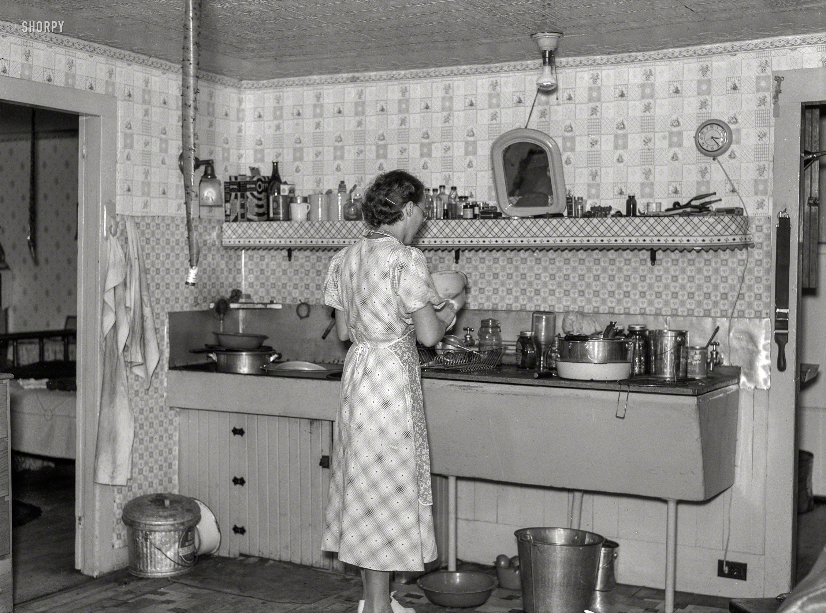 September 1937. "Hired girl washing dishes on the McNally farm. Kirby, Vermont." The kitchen last seen here. Medium format negative by Arthur Rothstein for the Farm Security Administration. View full size.