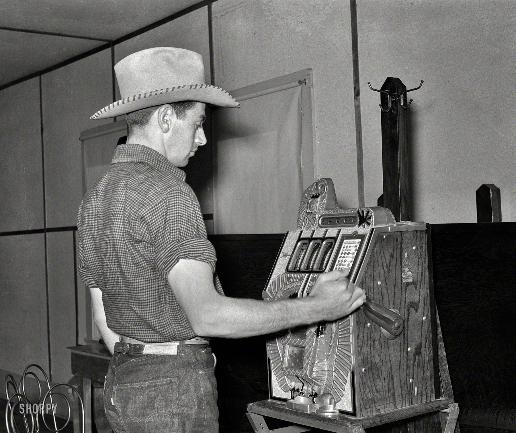 June 1939. Birney, Montana. "Dude playing a slot machine." Medium format negative by Arthur Rothstein, Farm Security Administration. View full size.