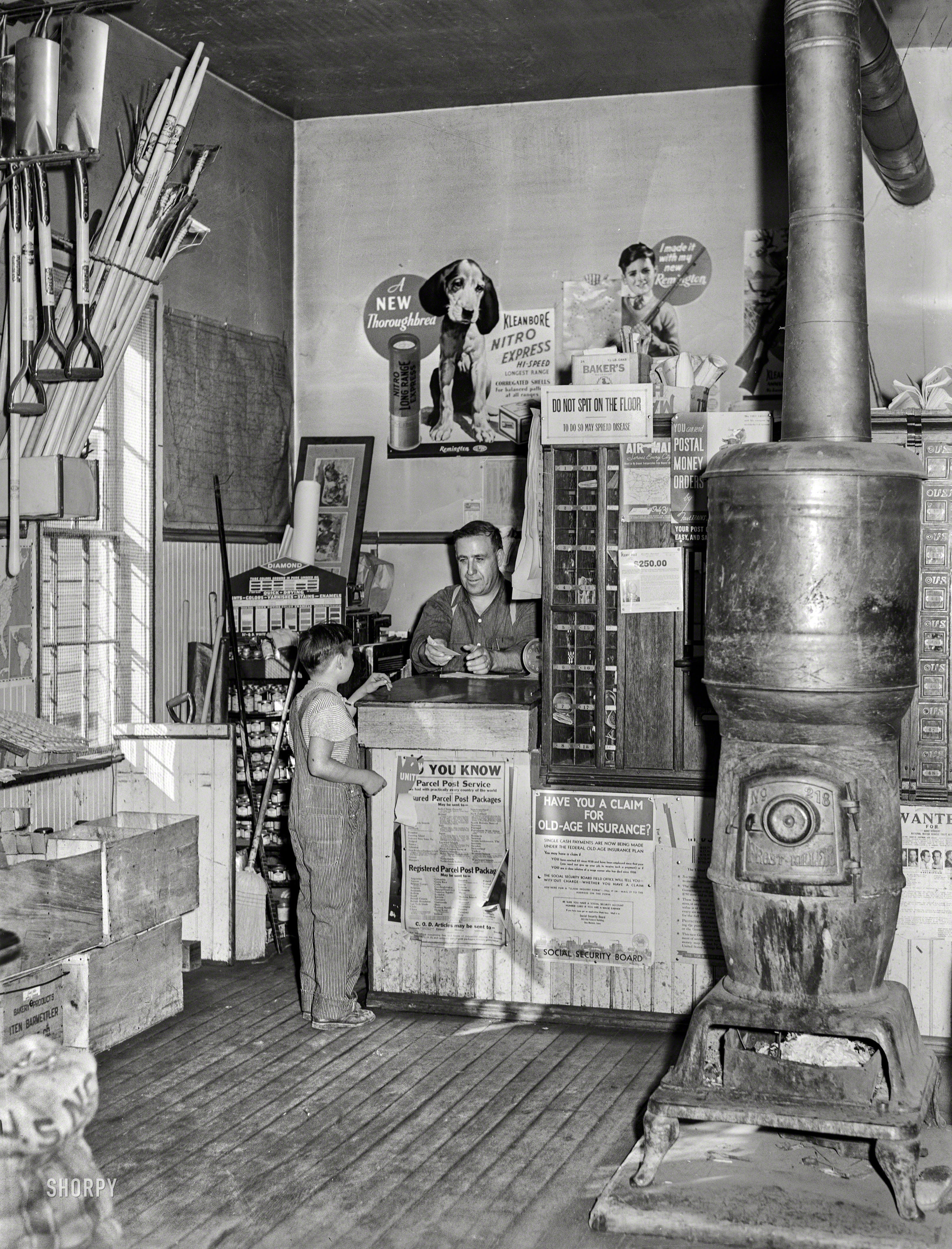 October 1939. "Post office in the general store. Lamoille, Iowa." Let's see now. Stamps, ammo, and a case of Iten-Barmettler, please! Medium format negative by Arthur Rothstein for the Farm Security Administration. View full size.