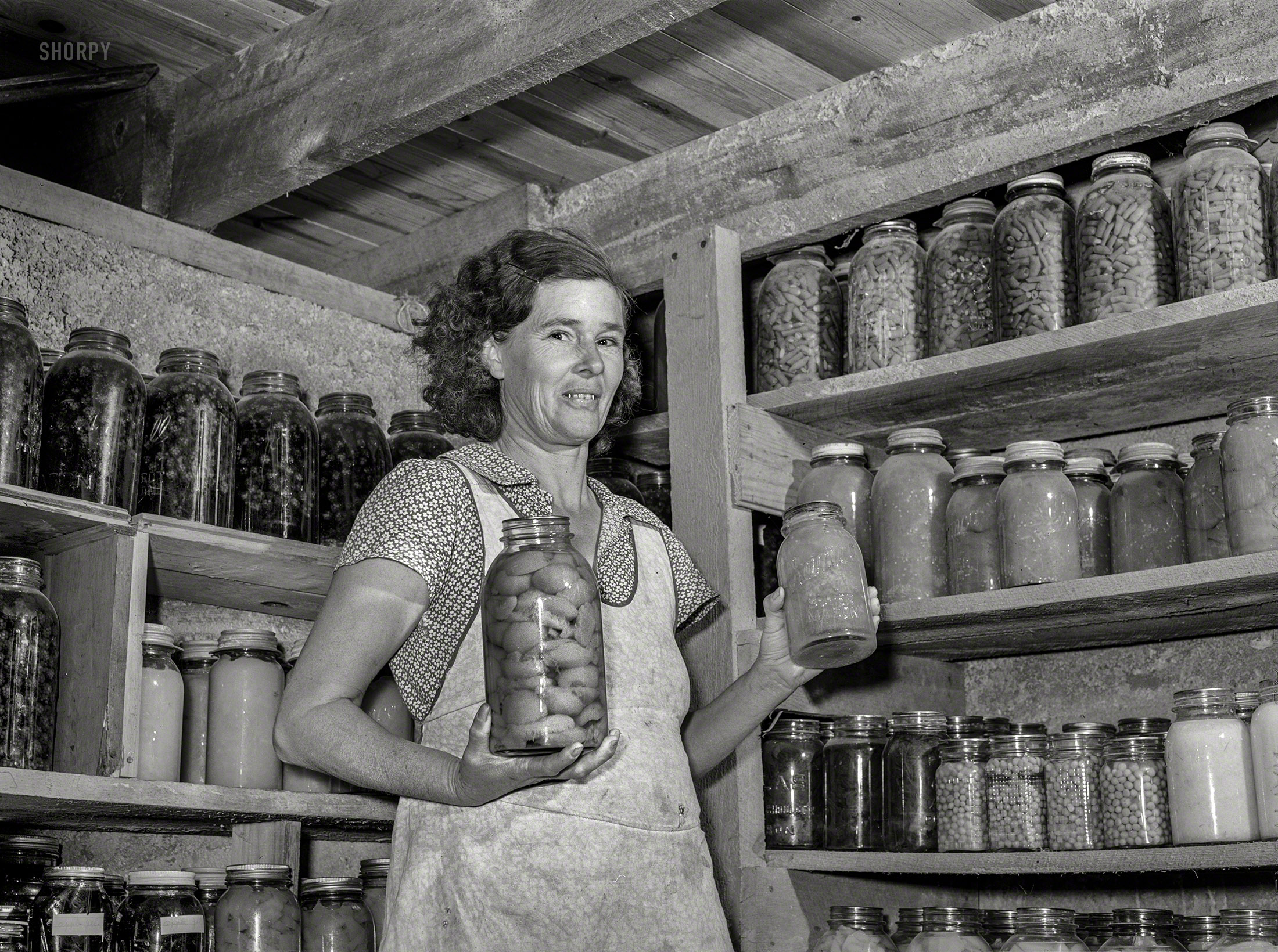 November 1939. "Mrs. Lawrence Corda, wife of tiff miner, with some of her 800 quarts of food canned under FSA supervision. Washington County, Missouri." Photo by Arthur Rothstein for the Farm Security Administration. View full size.