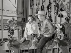 March 1940. "Cowhand trying saddle at saddlery in Elko, Nevada." Medium format acetate negative by Arthur Rothstein for the Farm Security Administration. View full size.