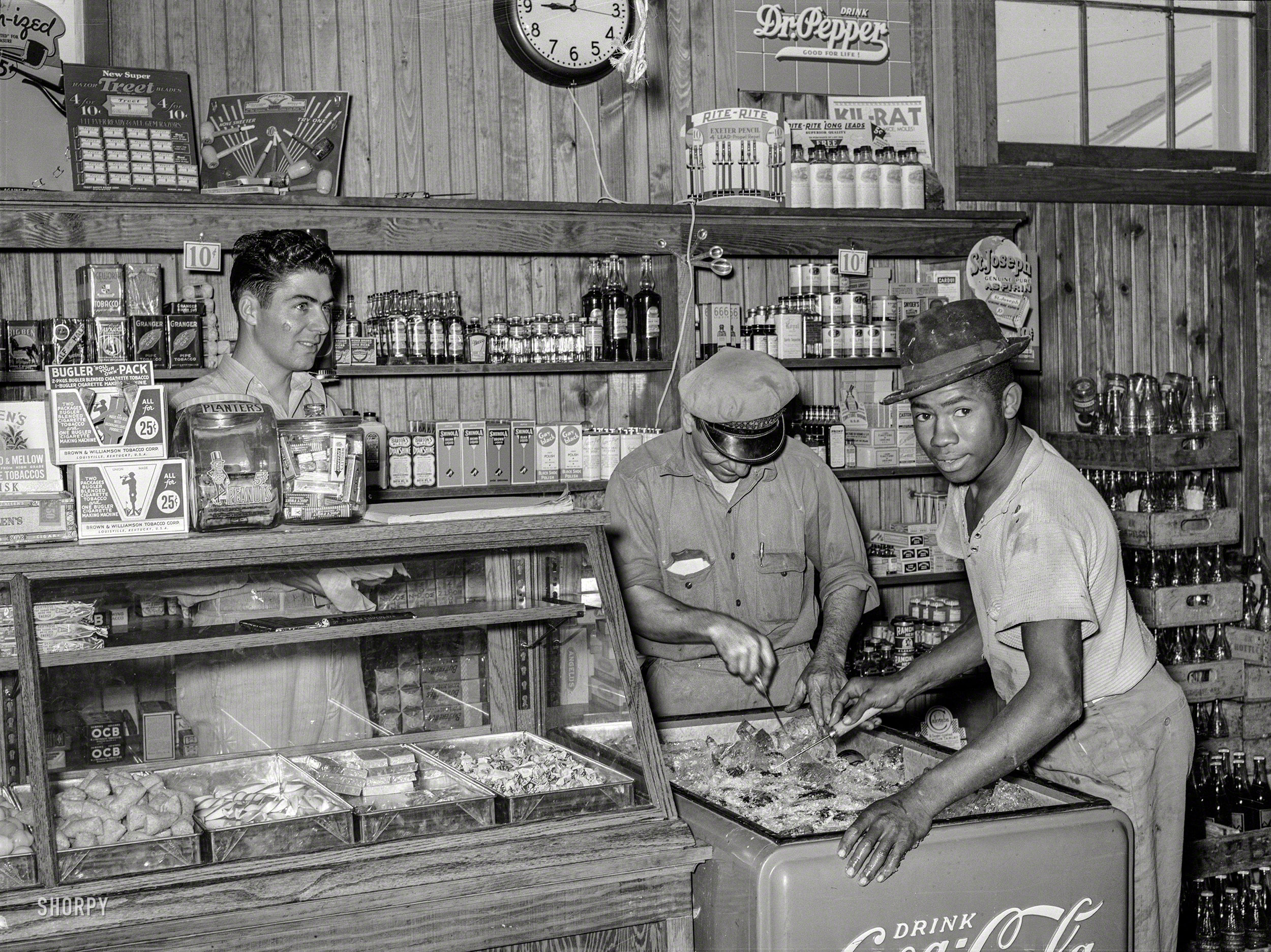 October 1938. "Icing soft drink refrigerator in general store of the Lake Dick cooperation association, a Farm Security Administration project near Altheimer, Arkansas." Medium format negative by Russell Lee for the FSA. View full size.