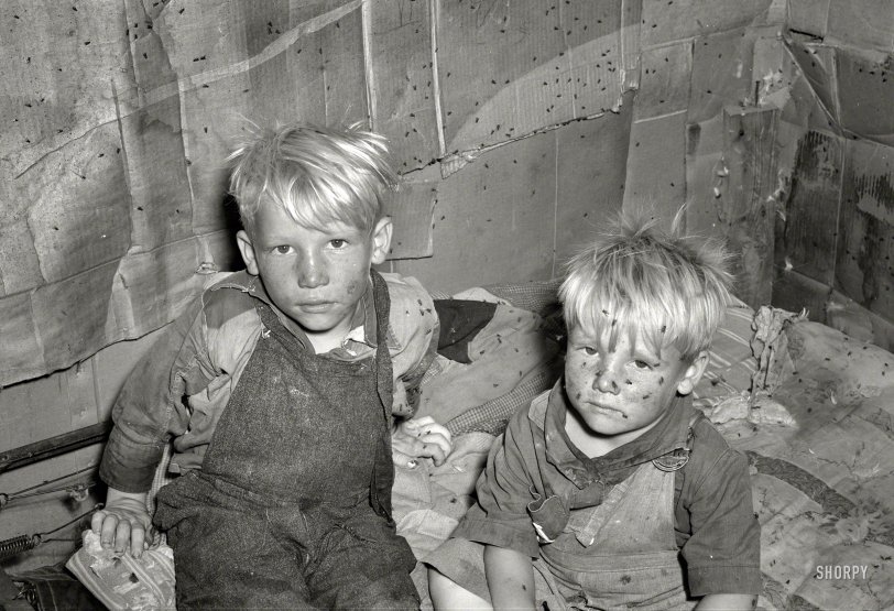 July 1939. Oklahoma City, Oklahoma. "Children of May Avenue camp family in small shack used as sleeping quarters. Poverty-stricken inhabitants here dwell in squalor, filth and vermin." Medium format acetate negative by Russell Lee for the Farm Security Administration. View full size.
