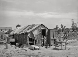 July 1939. "Shack of family living in May Avenue camp, Oklahoma City." Photo by Russell Lee for the Farm Security Administration. View full size.
&quot;I&#039;m bored, Mom.&quot;In case you've ever wondered what the definition of dirt poor was, this is it.
Wishing them wellAnother painful reminder of life for some during the Great Depression. Let's hope that one day these children were able to leave this poverty and live a life denied to them in 1939, so they might one day ride in the cars crossing the bridge or live in a home like the one with clean clothes drying on the line on the hill behind their shack.
(The Gallery, Kids, OKC, Russell Lee)