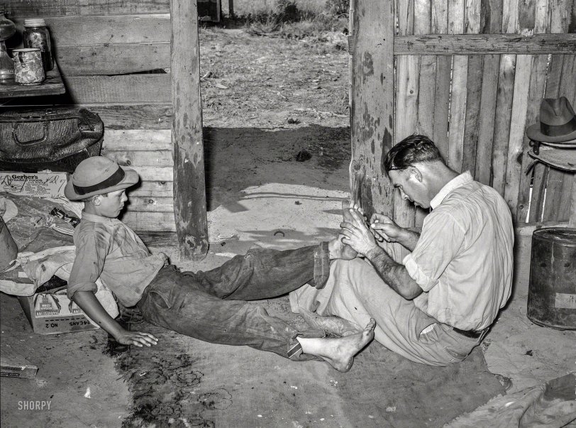 July 1939. "Resident of May Avenue camp, Oklahoma City, taking piece of glass out of boy's foot." Medium format negative by Russell Lee. View full size.
