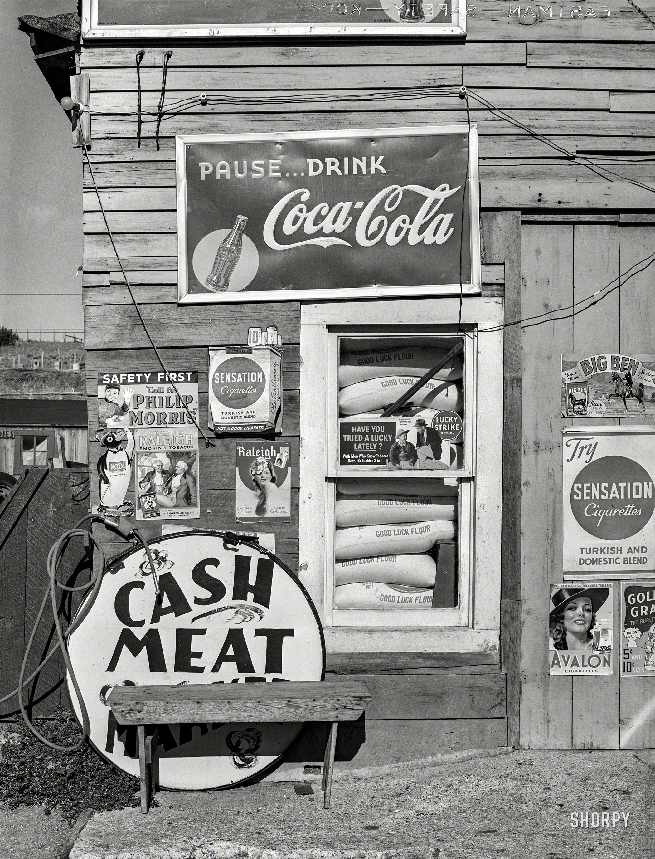 September 1939. "Detail of front of combined filling station and grocery store. Questa, New Mexico." Gasoline, caffeine, nicotine, protein. Medium format negative by Russell Lee for the Farm Security Administration. View full size.