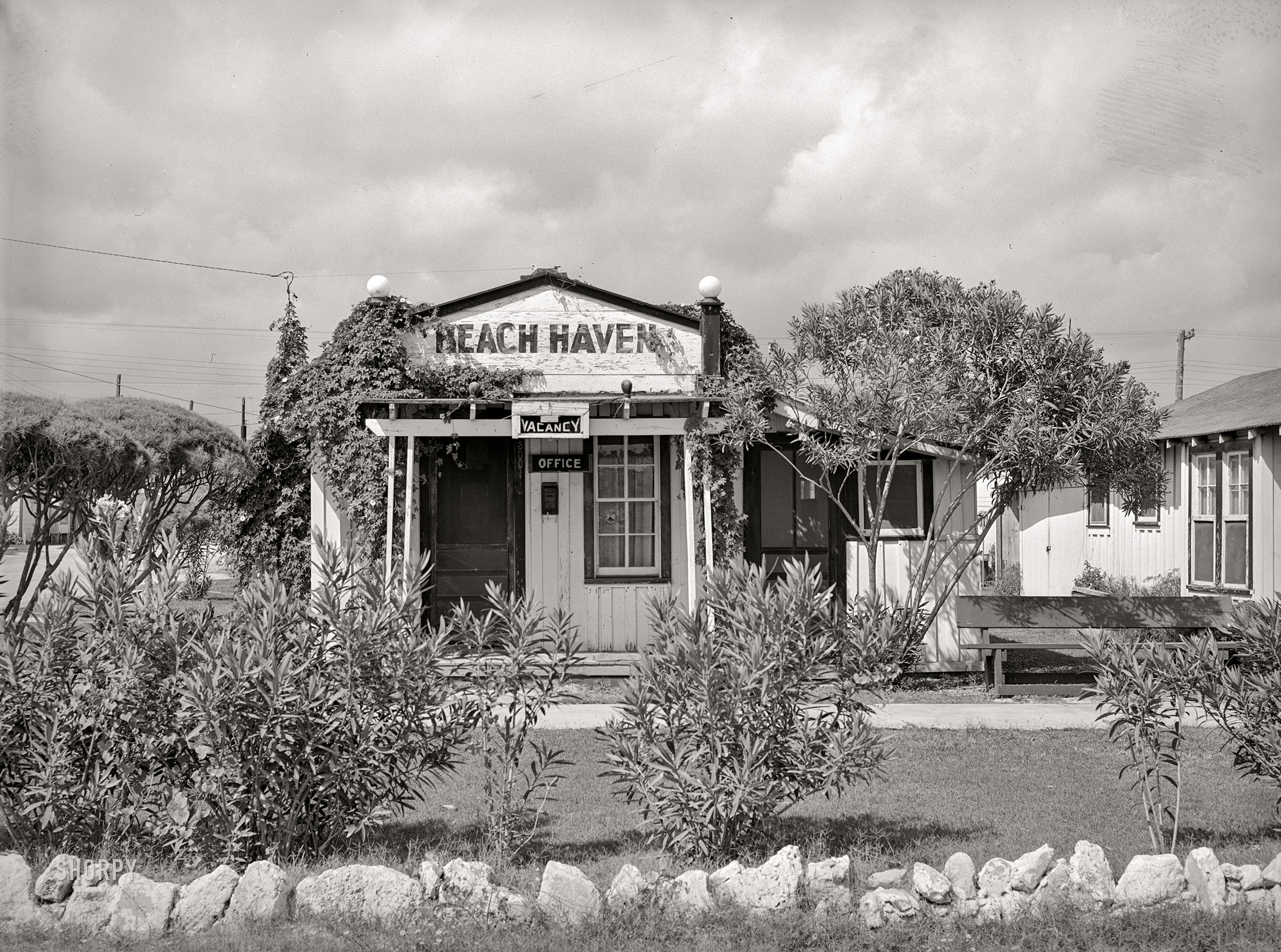 October 1939. "Corpus Christi, Texas. Boomtown areas around Naval Air Training Base. Office of tourist courts." Medium format acetate negative by Russell Lee. View full size.
