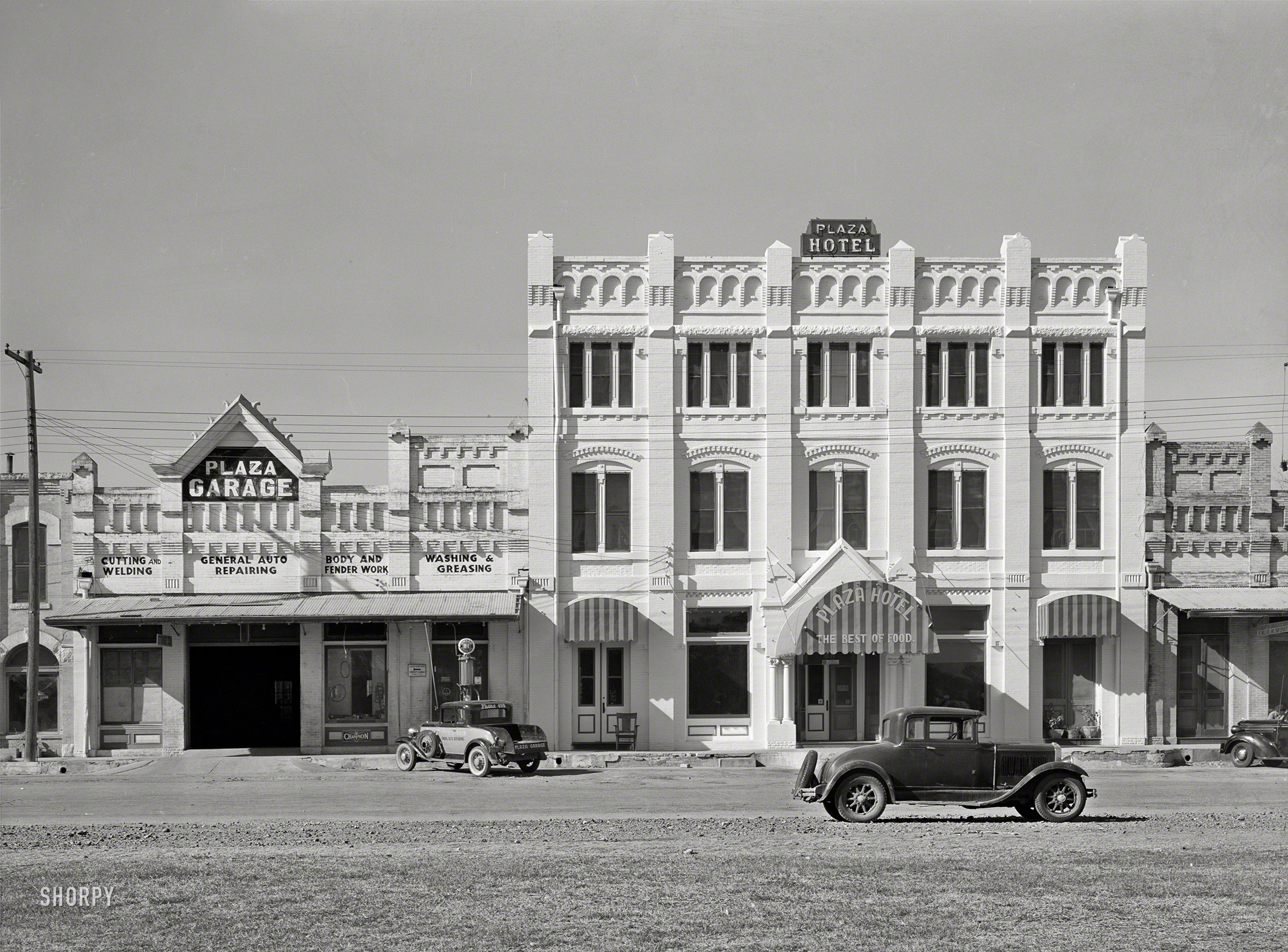 November 1939. "Hotel and garage in Gonzales, Texas." Medium format negative by Russell Lee for the Farm Security Administration. View full size.