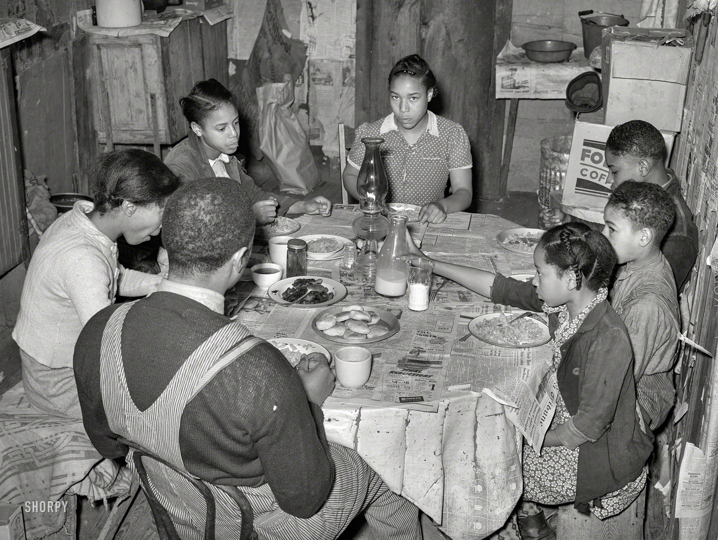 February 1940. "Family of tenant farmer Pomp Hall, eating breakfast consisting of corn flakes, biscuits, fried bacon, milk and coffee. Creek County, Oklahoma." Photo by Russell Lee for the Farm Security Administration. View full size.