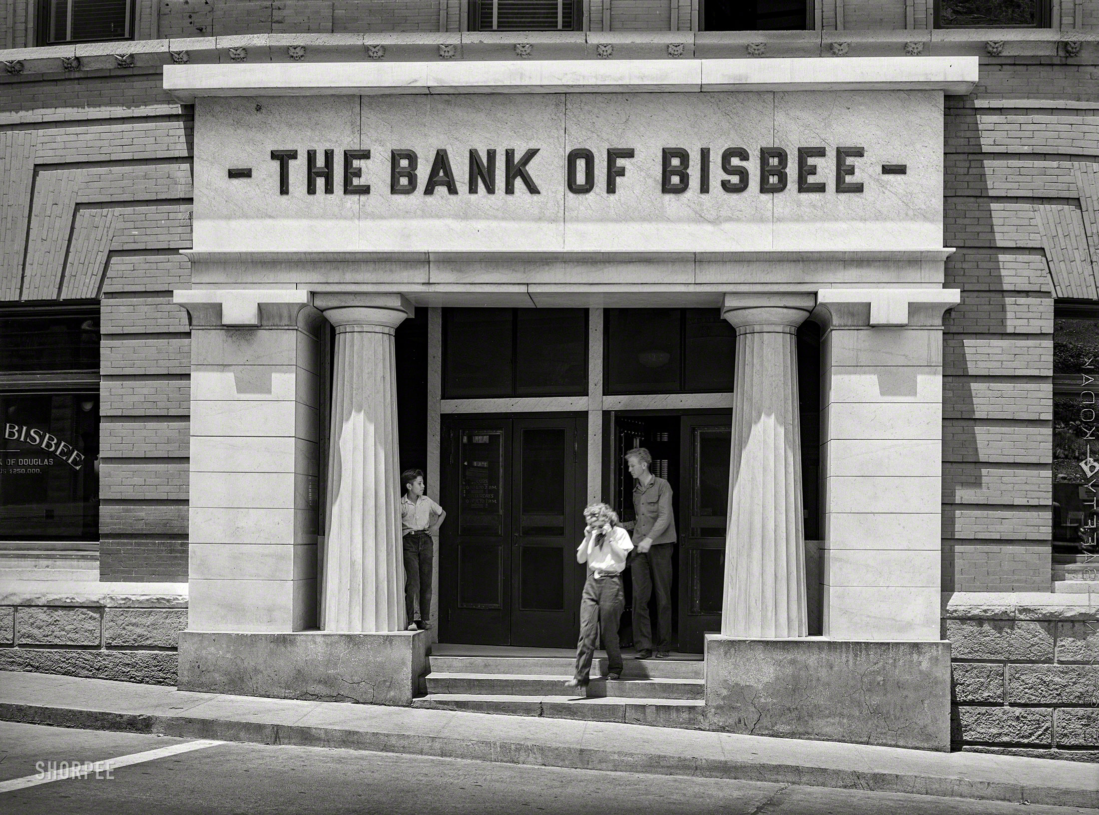 &nbsp; &nbsp; &nbsp; &nbsp; The Bank of Bisbee had a starring role in "Violent Saturday," a 1955 film noir shot on location with Bisbee recast as "Bradenville," and Ernest Borgnine somewhat improbably playing an Amish farmer whose family is held hostage by bank robbers.
May 1940. "Bank in copper mining center of Bisbee, Arizona." Medium format negative by Russell Lee for the Farm Security Administration. View full size.