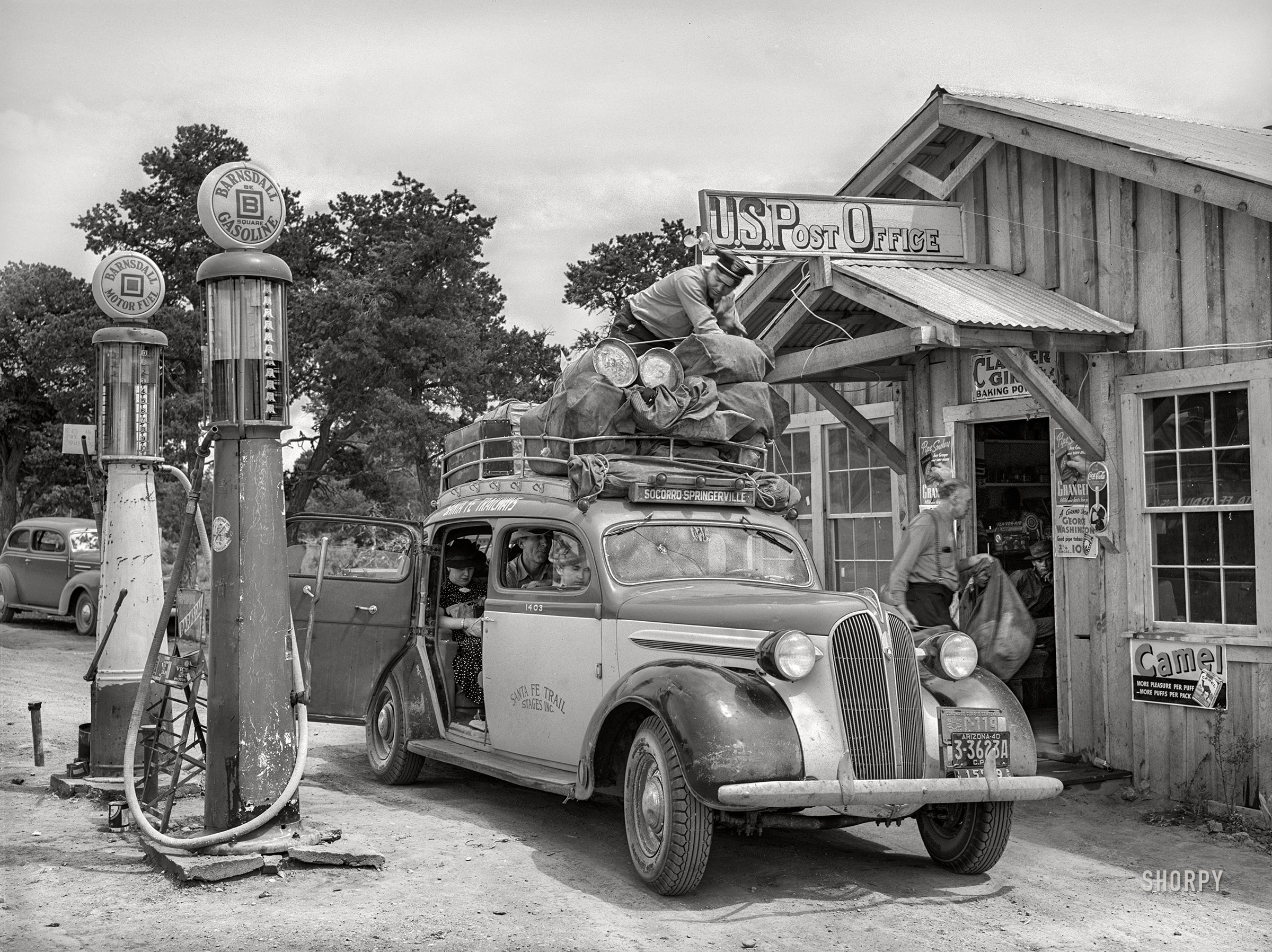 June 1940. "Stage in front of the post office at Pie Town, New Mexico. This stage comes through daily except Sunday. It takes in cream for the Pie Town farmers to Magdalena and Socorro and then returns the empty cans." Our second look at the Pie Town stop of the Socorro-Springerville Express. Medium format negative by Russell Lee. View full size.
