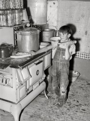 July 1940. "Spanish-American boy eating sweet corn which he has roasted on top of hot stove. Chamisal, New Mexico." Photo by Russell Lee, Farm Security Administration. View full size.
